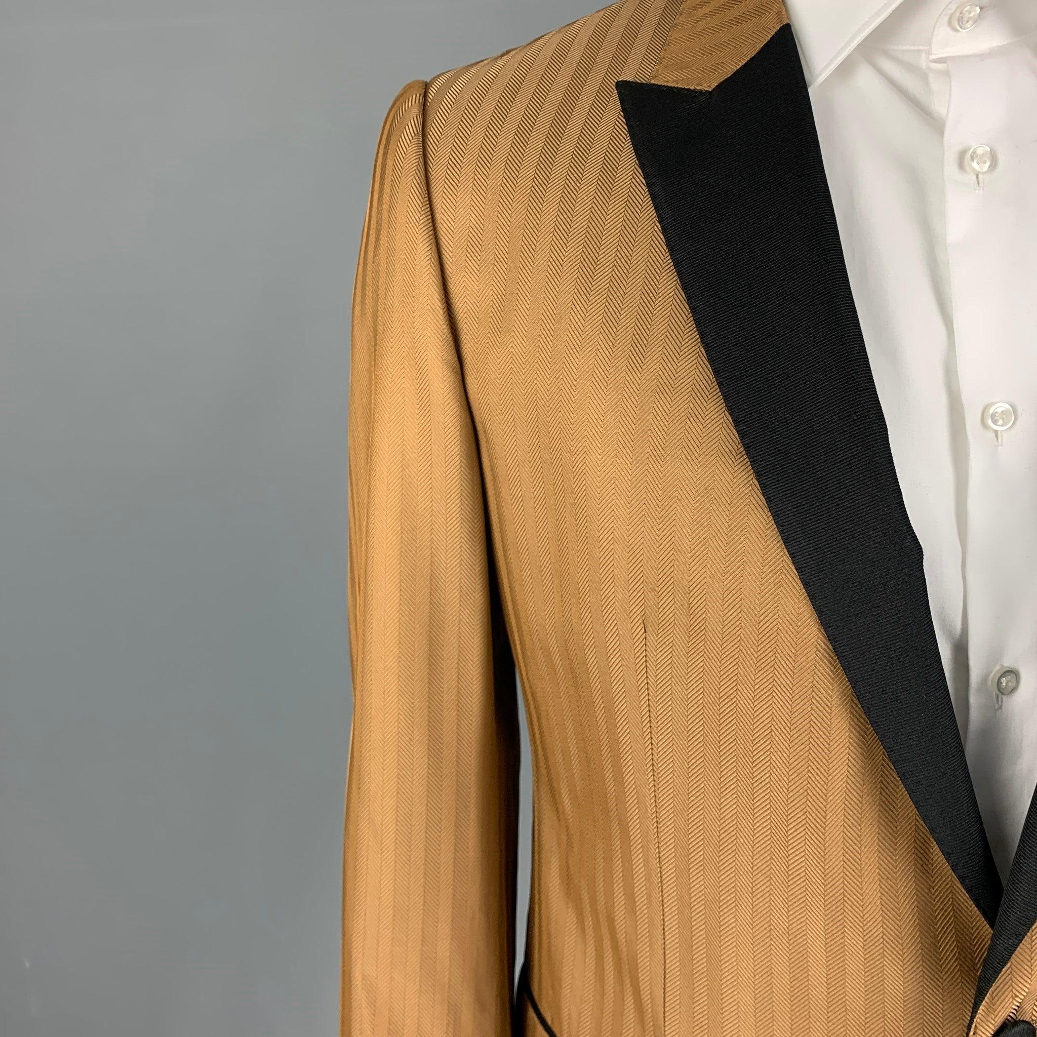 DOLCE & GABBANA sport coat comes in a tan herringbone silk blend with a full liner featuring a black peak lapel, flap pockets, single back vent, and a double button closure. Made in Italy.
Excellent
Pre-Owned Condition. 

Marked:   52