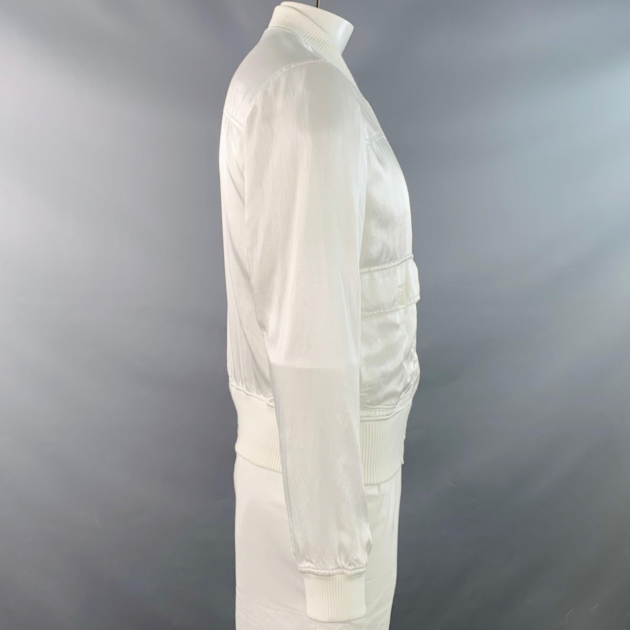 DOLCE & GABBANA bomber jacket
in a white cotton stretch blend fabric featuring two buttoned flap pockets, long sleeves, and zip up closure.Very Good Pre-Owned Condition. Minor signs of wear. 

Marked:   IT 52 

Measurements: 
 
Shoulder: 16.5 inches