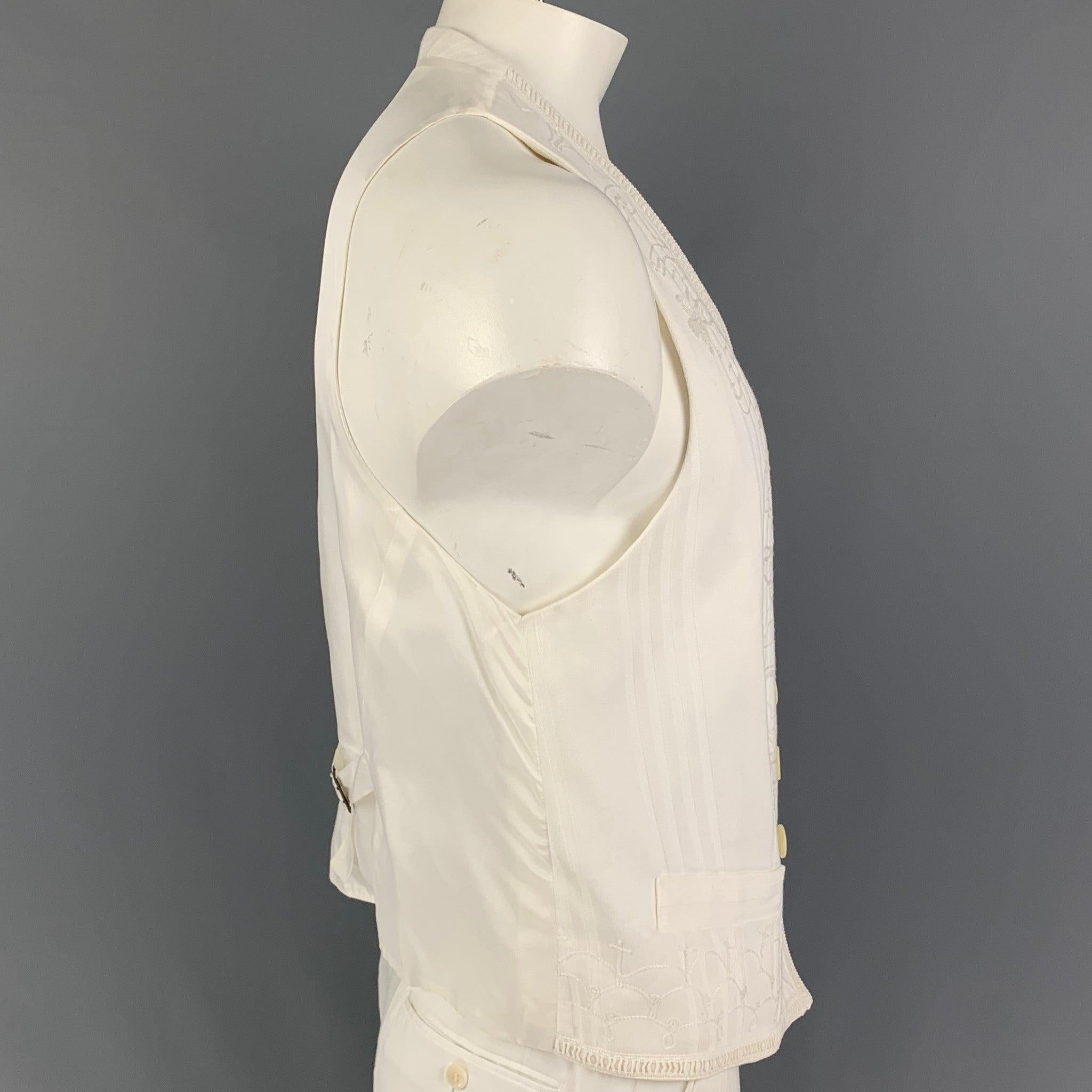 DOLCE & GABBANA vest comes in a white cotton featuring embroidered designs, adjustable back strap, slit pockets, and a buttoned closure. Made in Italy.
Very Good
Pre-Owned Condition. Fabric tag removed.  

Marked:   Size tag removed 

Measurements: