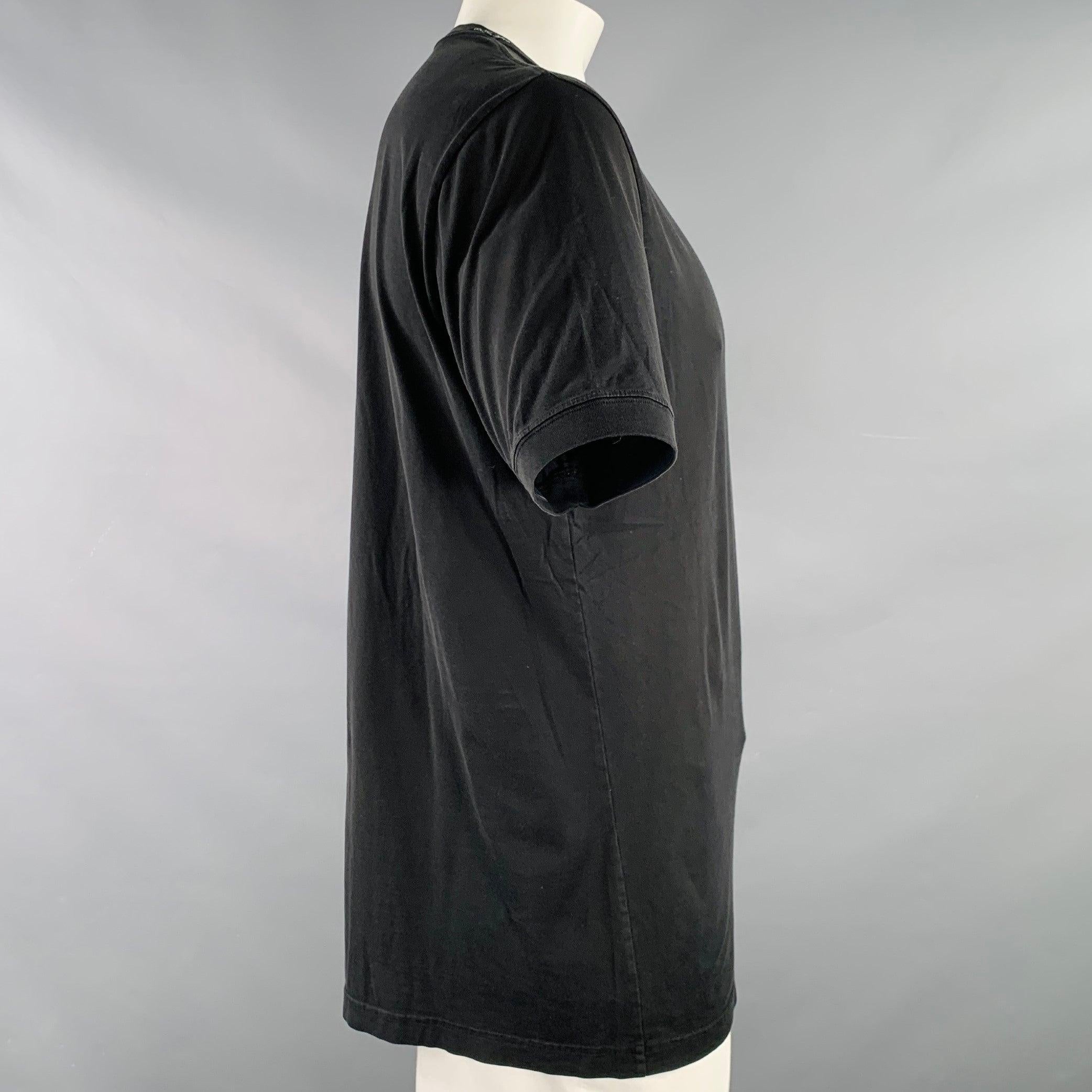 DOLCE & GABBANA t-shirt
in a black cotton jersey featuring a distresed design, short sleeves, button neckline details, and V-neck. Made in Italy.Excellent Pre-Owned Condition. Distress is an intentional part of the design. 

Marked:   size not