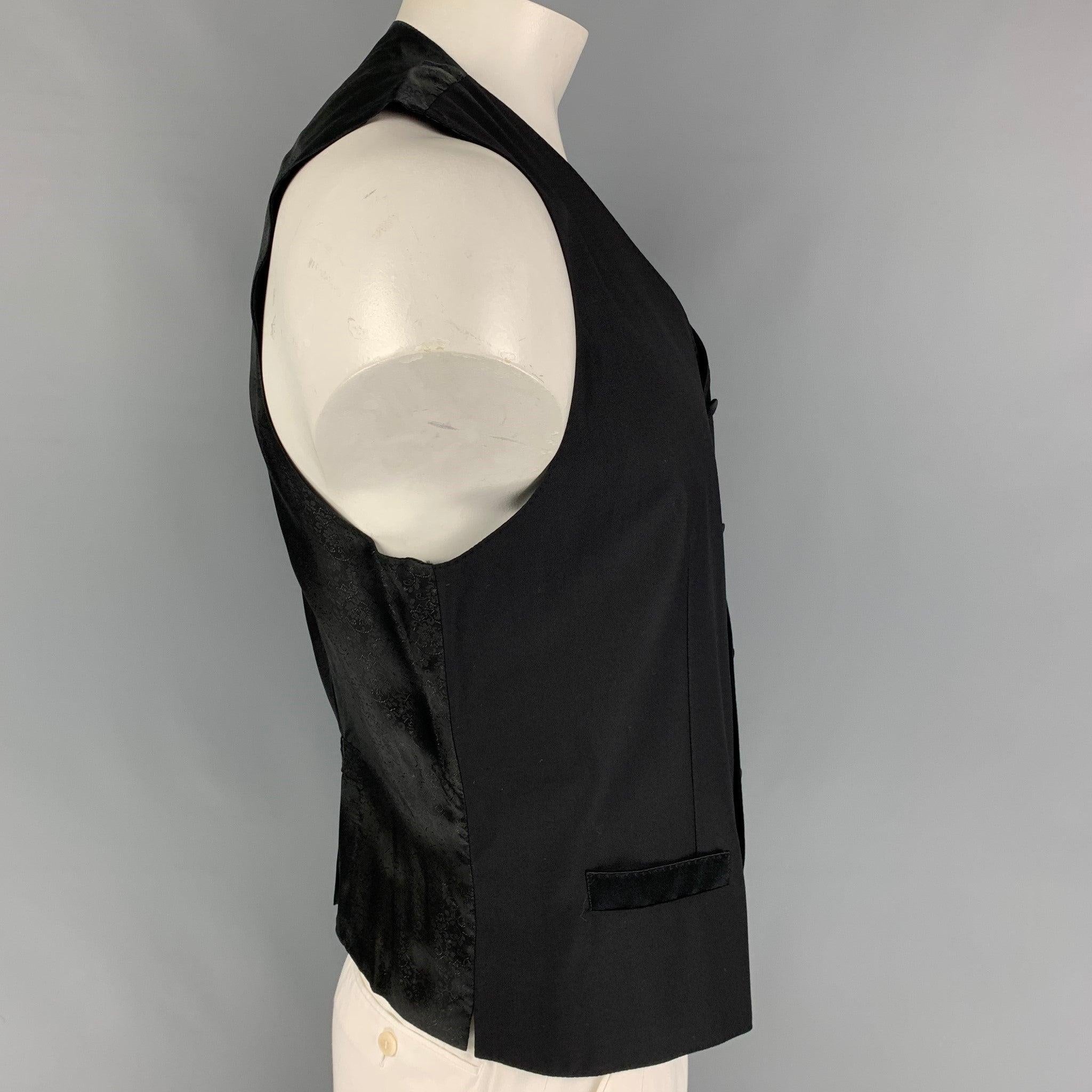 DOLCE & GABBANA vest comes in a black wool / silk featuring a back belt, slit pockets, and a buttoned closure. Made in Italy.
Very Good
Pre-Owned Condition. 

Marked:   54 

Measurements: 
 
Shoulder: 15.5 inches  Chest: 44 inches  Length: 24 inches