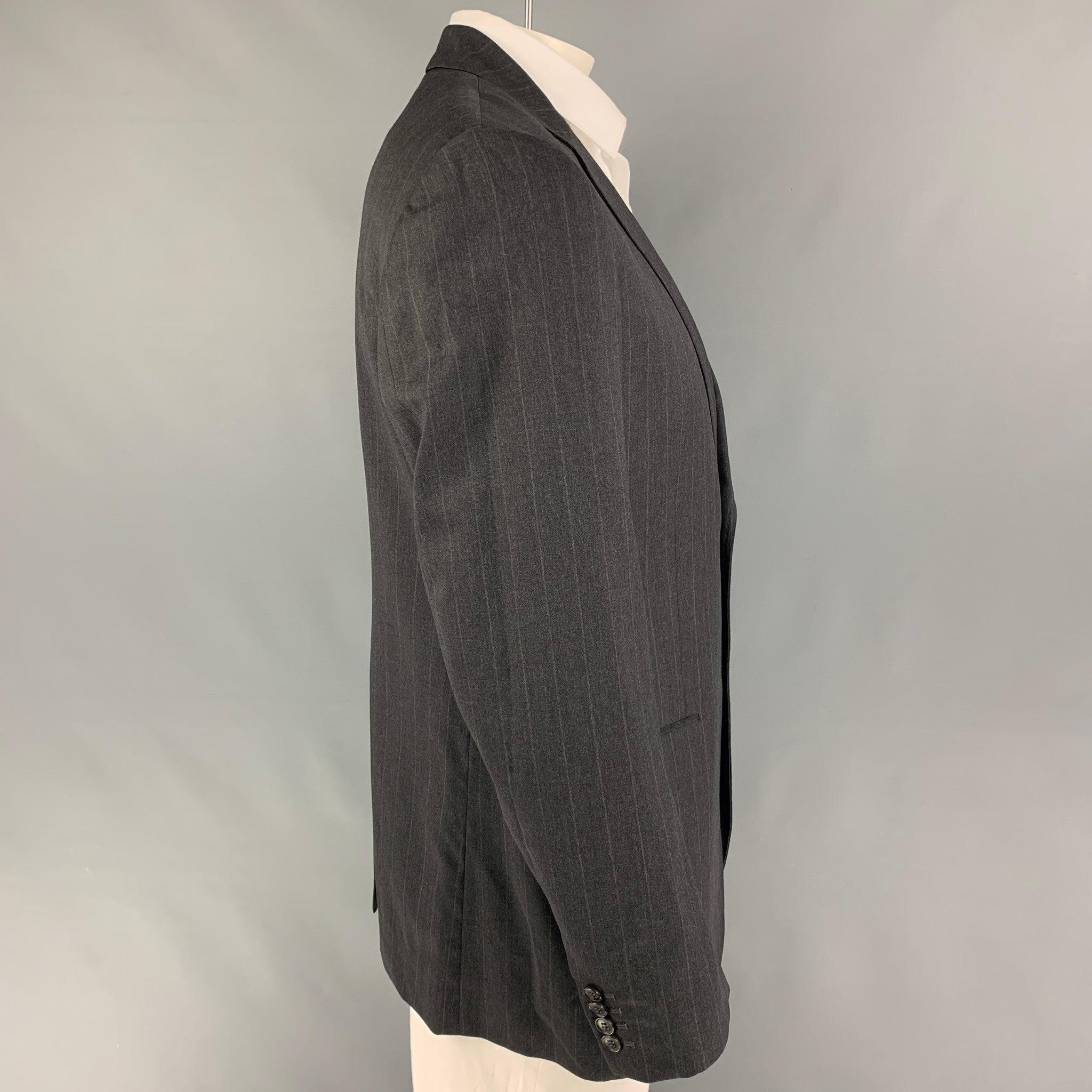 DOLCE & GABBANA
sport coat comes in a charcoal pinstripe virgin wool with a full liner featuring a notch lapel, flap pockets, single back vent, and a double button closure. Made in Italy. Very Good Pre-Owned Condition. 

Marked:   54 

Measurements: