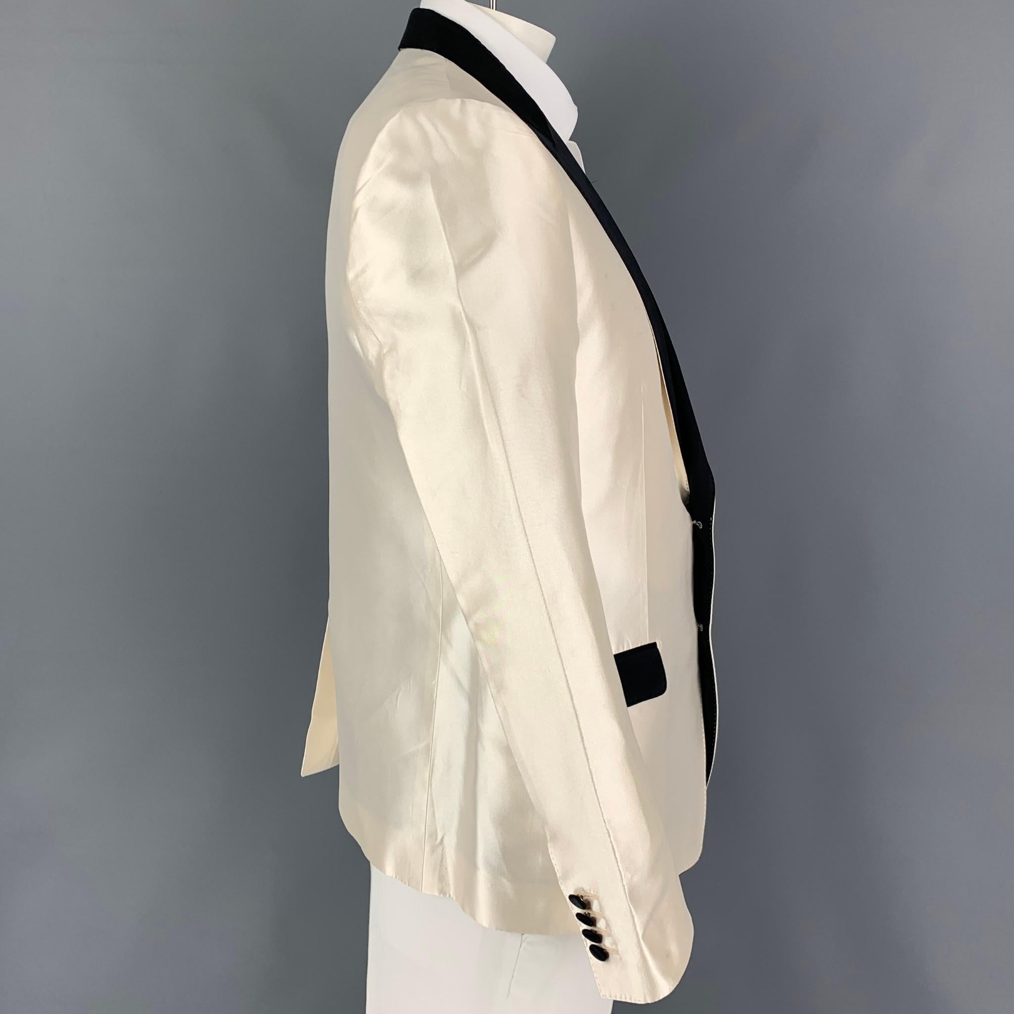 DOLCE & GABBANA sport coat comes in a beige & black silk blend with a full liner featuring a peak lapel, flap pockets, single back vent, and a double button closure. Made in Italy. 

Good Pre-Owned Condition. Moderate discoloration throughout.