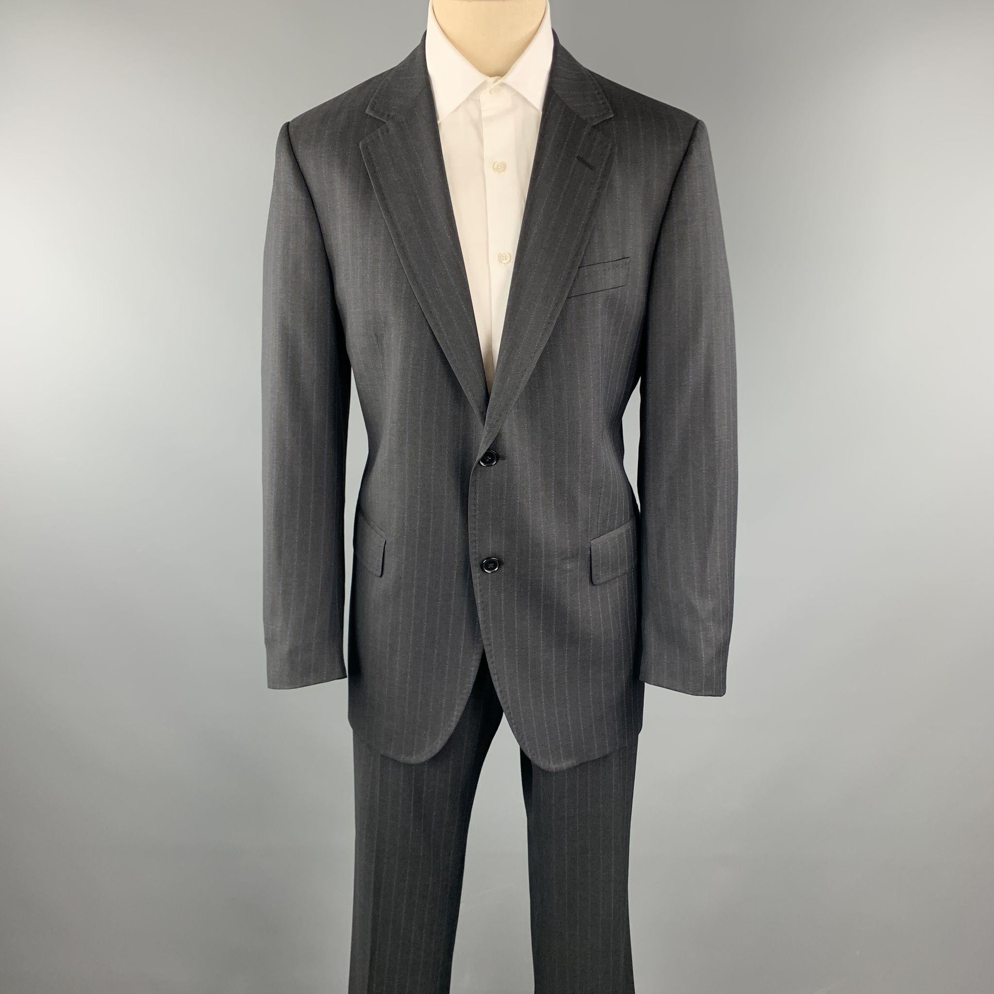DOLCE & GABBANA suit comes in a charcoal stripe wool and includes a single breasted, two button sport coat with a notch lapel and matching pleated front trousers. Made in Italy.

Excellent Pre-Owned Condition.
Marked: IT