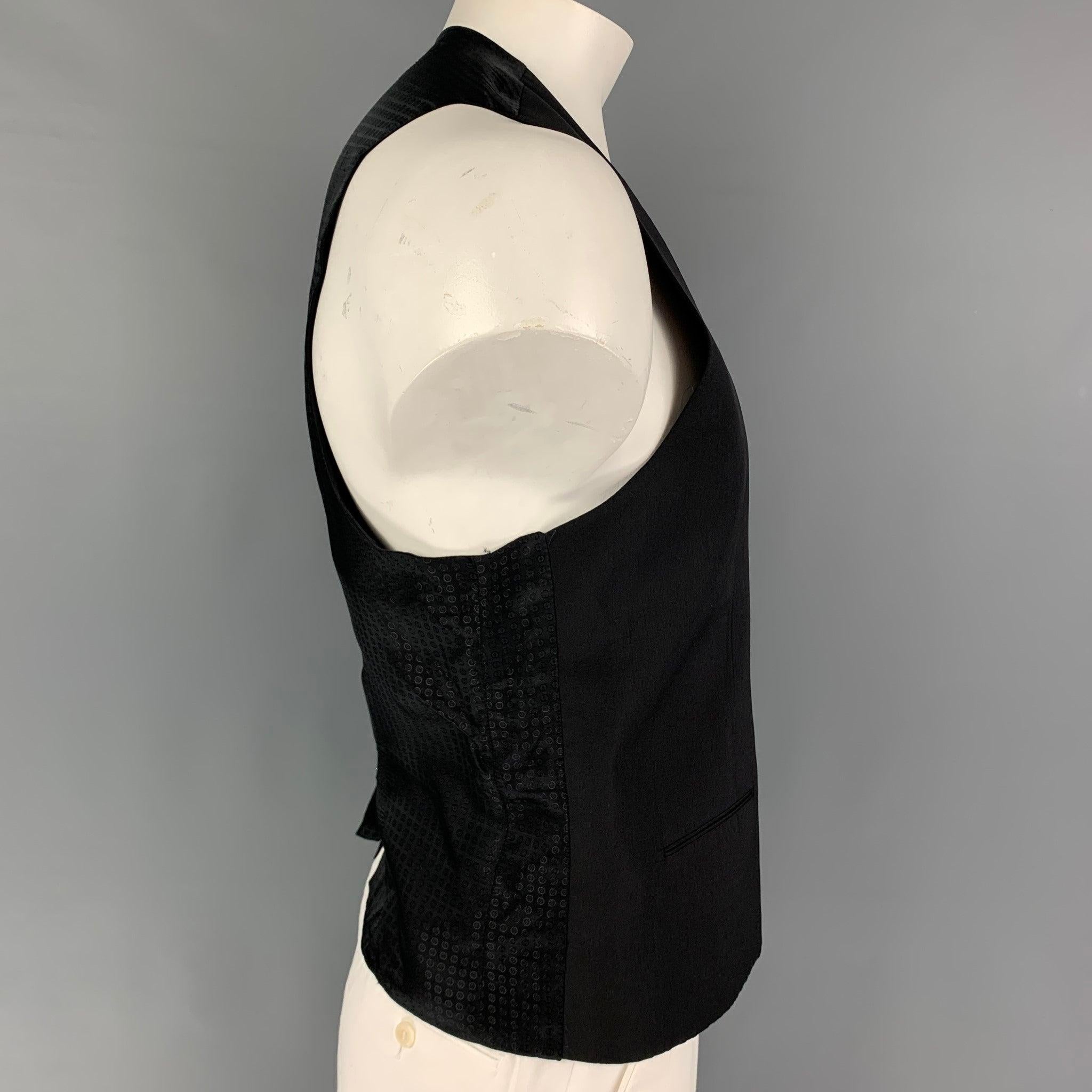 DOLCE & GABBANA vest comes in a black wool / silk featuring a back belt, slit pockets, and a buttoned closure. Made in Italy.
Very Good
Pre-Owned Condition. 

Marked:   56 

Measurements: 
 
Shoulder: 15.5 inches  Chest: 46 inches  Length: 25 inches