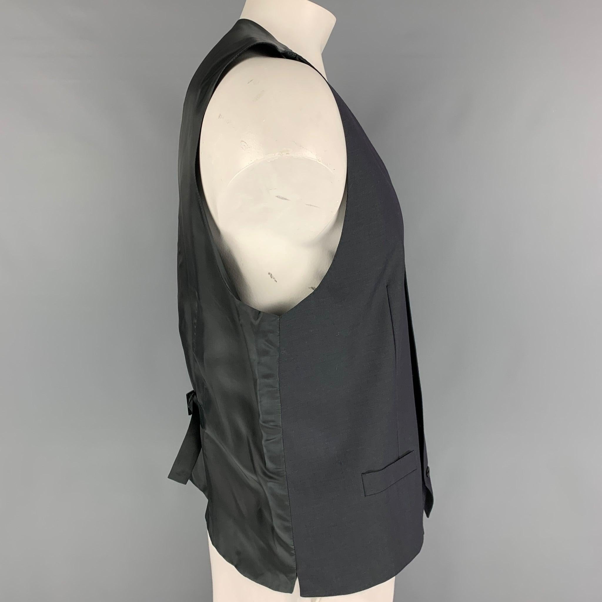 DOLCE & GABBANA
dress vest comes in a charcoal iridescent wool / mohair featuring a back belt, front pockets, and a buttoned closure.
Very Good
Pre-Owned Condition. 

Marked:   Size tag removed.  

Measurements: 
 
Shoulder: 16 inches  Chest: 44