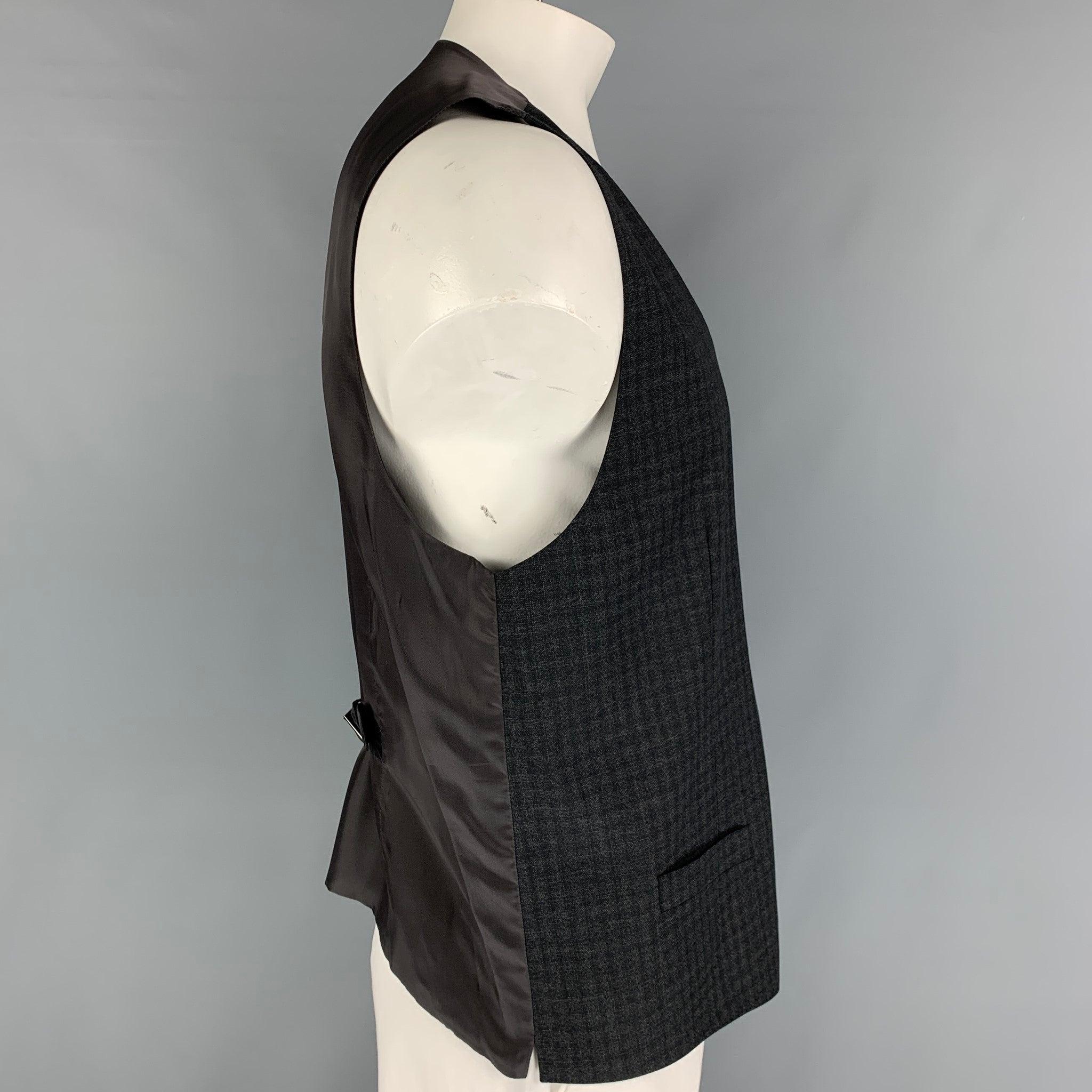 DOLCE & GABBANA
dress vest comes in a charcoal wool featuring a back belt, front pockets, and a buttoned closure.
Very Good
Pre-Owned Condition. 

Marked:   Size tag removed.  

Measurements: 
 
Shoulder: 16 inches  Chest: 44 inches  Length: 25