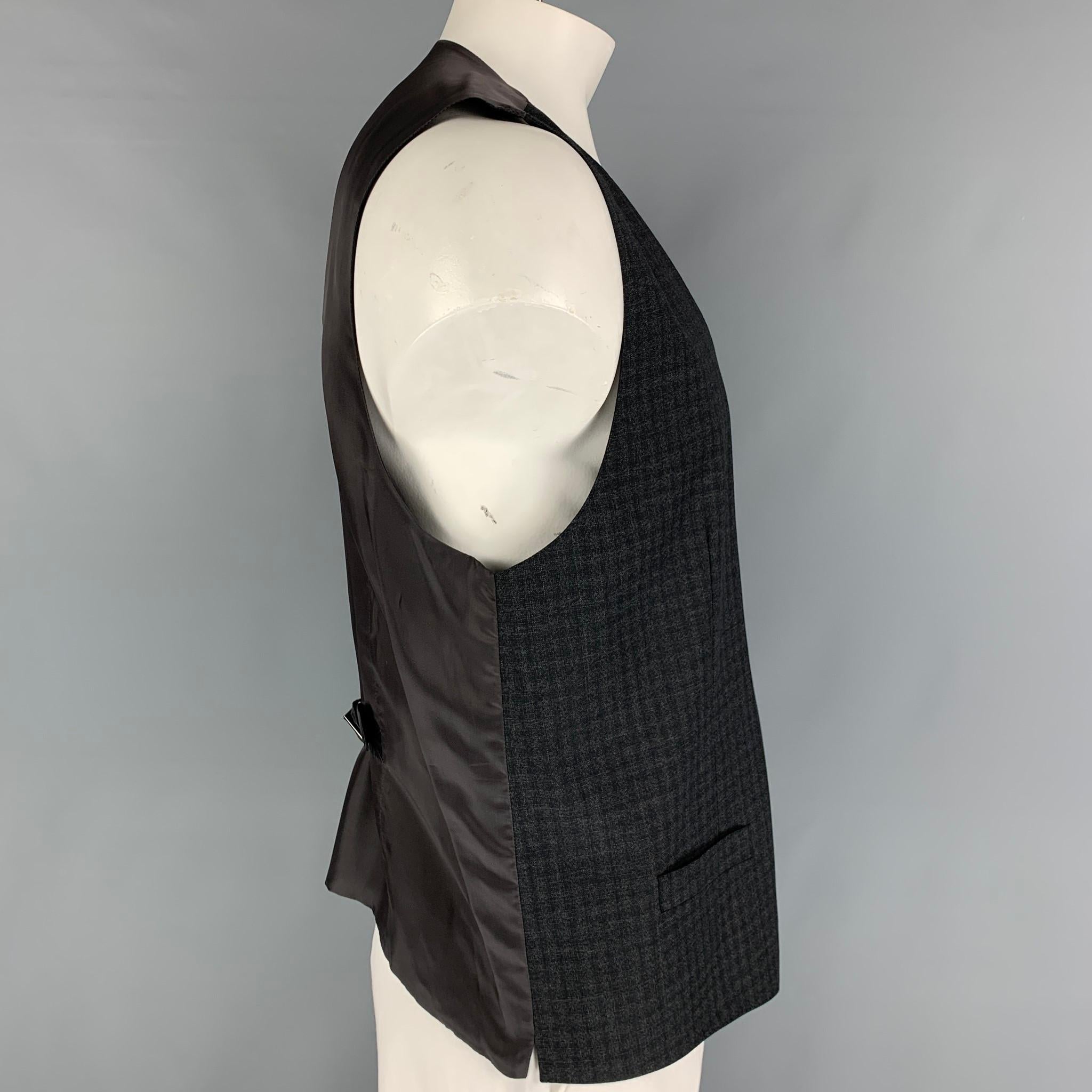 DOLCE & GABBANA dress vest comes in a charcoal wool featuring a back belt, front pockets, and a buttoned closure. 

Very Good Pre-Owned Condition.
Marked: Size tag removed.

Measurements:

Shoulder: 16 in.
Chest: 44 in.
Length: 25 in. 