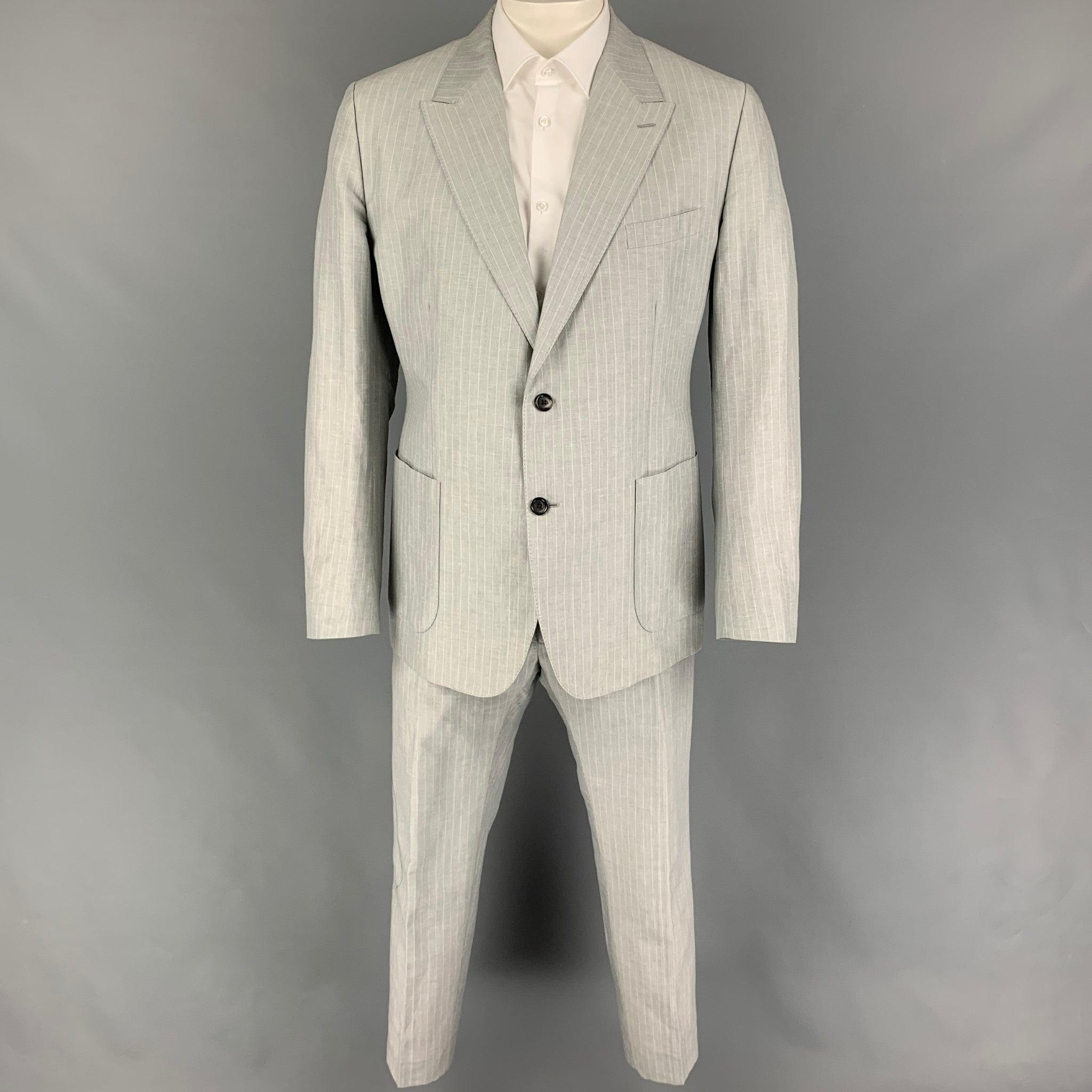 DOLCE & GABBANA
suit comes in a light gray stripe linen / cotton with a half liner and includes a single breasted, double button sport coat with a peak lapel and matching flat front trousers. Made in Italy. Very Good Pre-Owned Condition. 

Marked:  