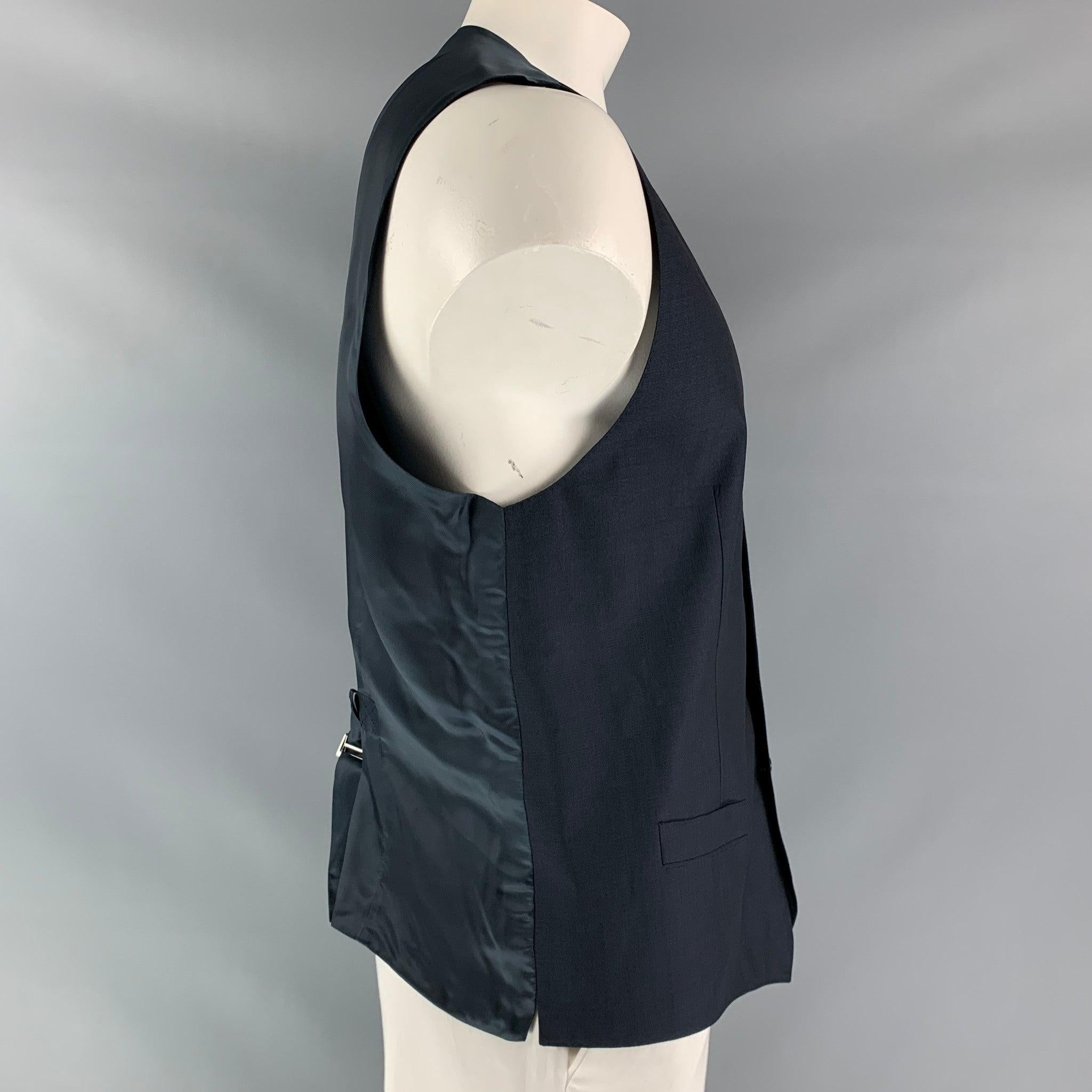 DOLCE & GABBANA dress vest comes in a navy mohair and wool fabric, full lined featuring V-neck, welt pockets, five buttons down closure, navy viscose fabric back and adjustable sliding belt. Made in Italy.Excellent Pre-Owned Condition.  

Marked:  