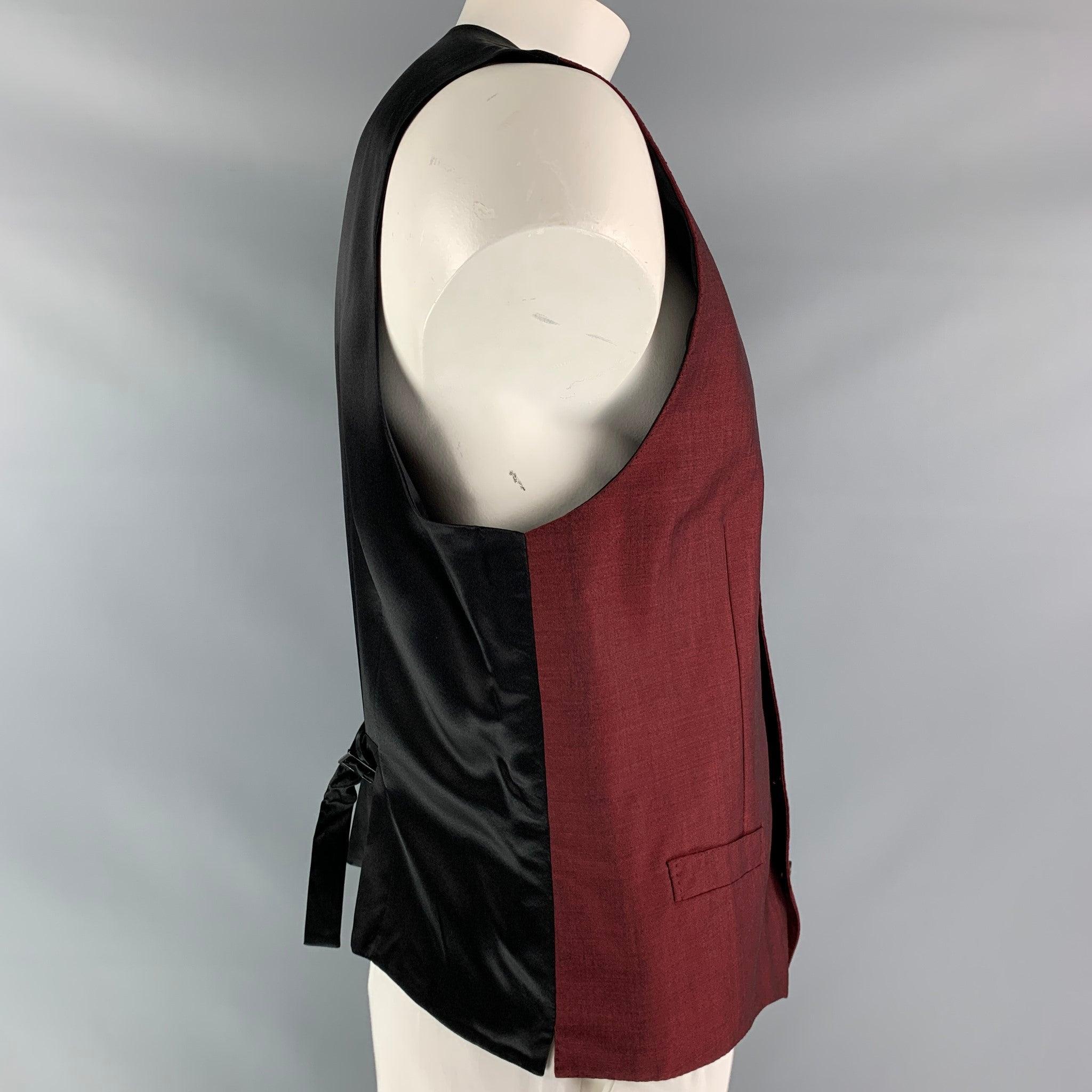 DOLCE & GABBANA alta sartoria dress vest comes in a burgundy wool, mohair and silk fabric, full lined featuring V- neck, welt pockets, five buttons down closure, black silk satin fabric at back and adjustable belt. Made in Italy.Excellent Pre-Owned