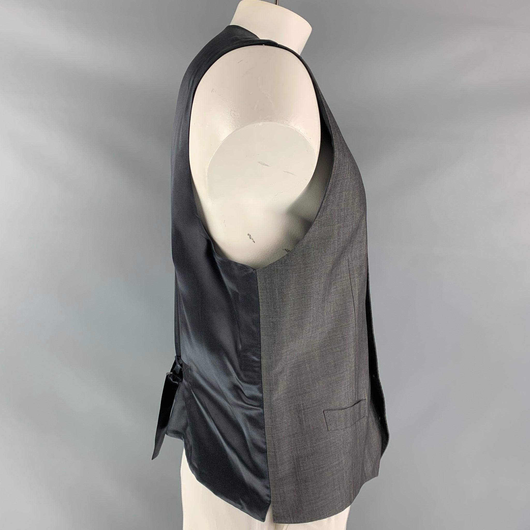 DOLCE & GABBANA alta sartoria dress vest comes in a grey wool, mohair and silk fabric, full lined featuring V- neck, welt pockets, five buttons down closure, dark grey silk satin fabric at back and adjustable belt. Made in Italy.Excellent Pre-Owned