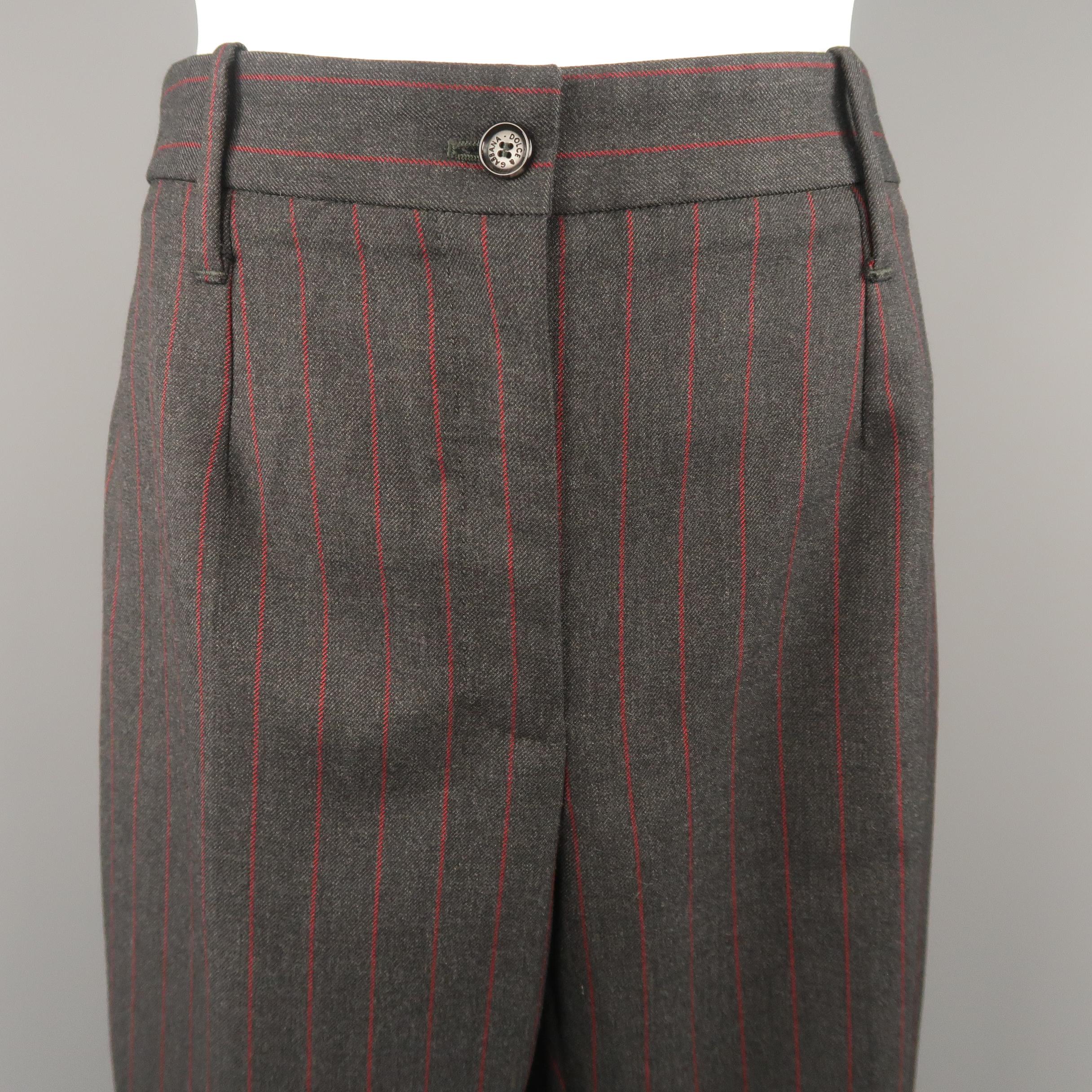 DOLCE & GABBANA dress pants come in charcoal wool twill with red chalk stripe pattern throughout and darted flat front, wide leg with oversized cuff, cropped hem. Made in Italy.
 
Excellent Pre-Owned Condition.
Marked: IT 42
 
Measurements:
 
Waist: