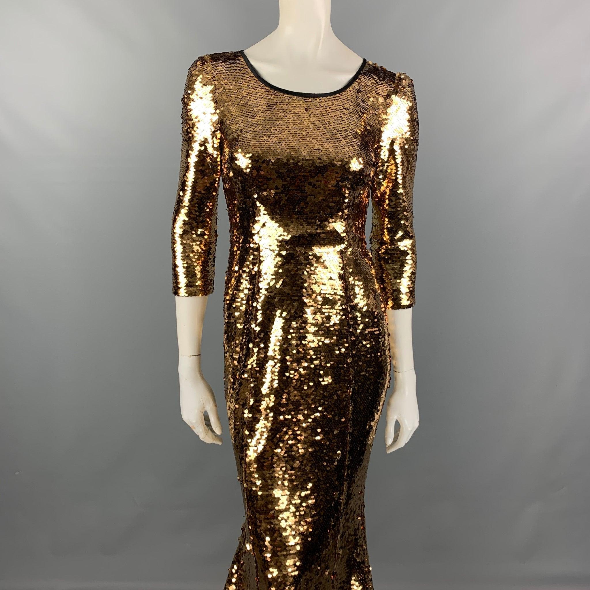 Das Kleid von DOLCE & GABBANA besteht aus gold-schwarzem, paillettenbesetztem Polyester, hat eine Meerjungfrauen-Schleppe, einen ausgestellten, gerafften Saum, 3/4-Ärmel und einen unsichtbaren Reißverschluss. Hergestellt in Italien. Sehr