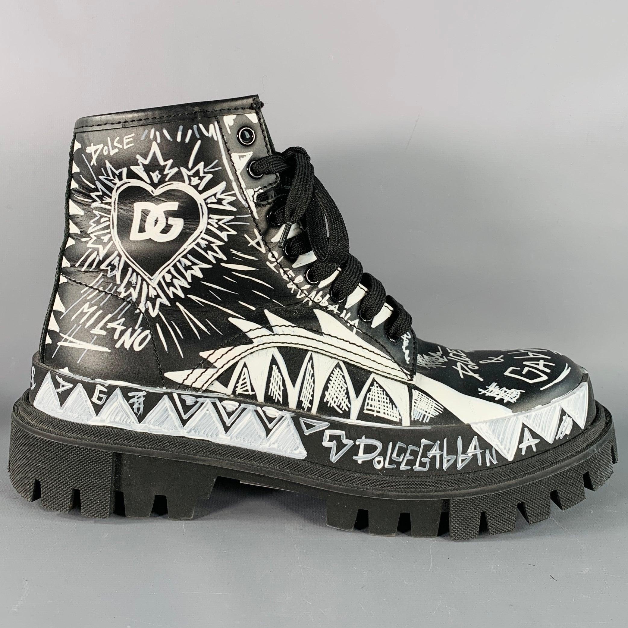 DOLCE & GABBANA boots
in a black leather featuring an all over white painted design with logo details, chunky rubber lug sole, and lace-up closure. Made in Italy.Very Good Pre-Owned Condition. Creasing on toes. 

Marked:   CS2052 8 

Measurements: 

