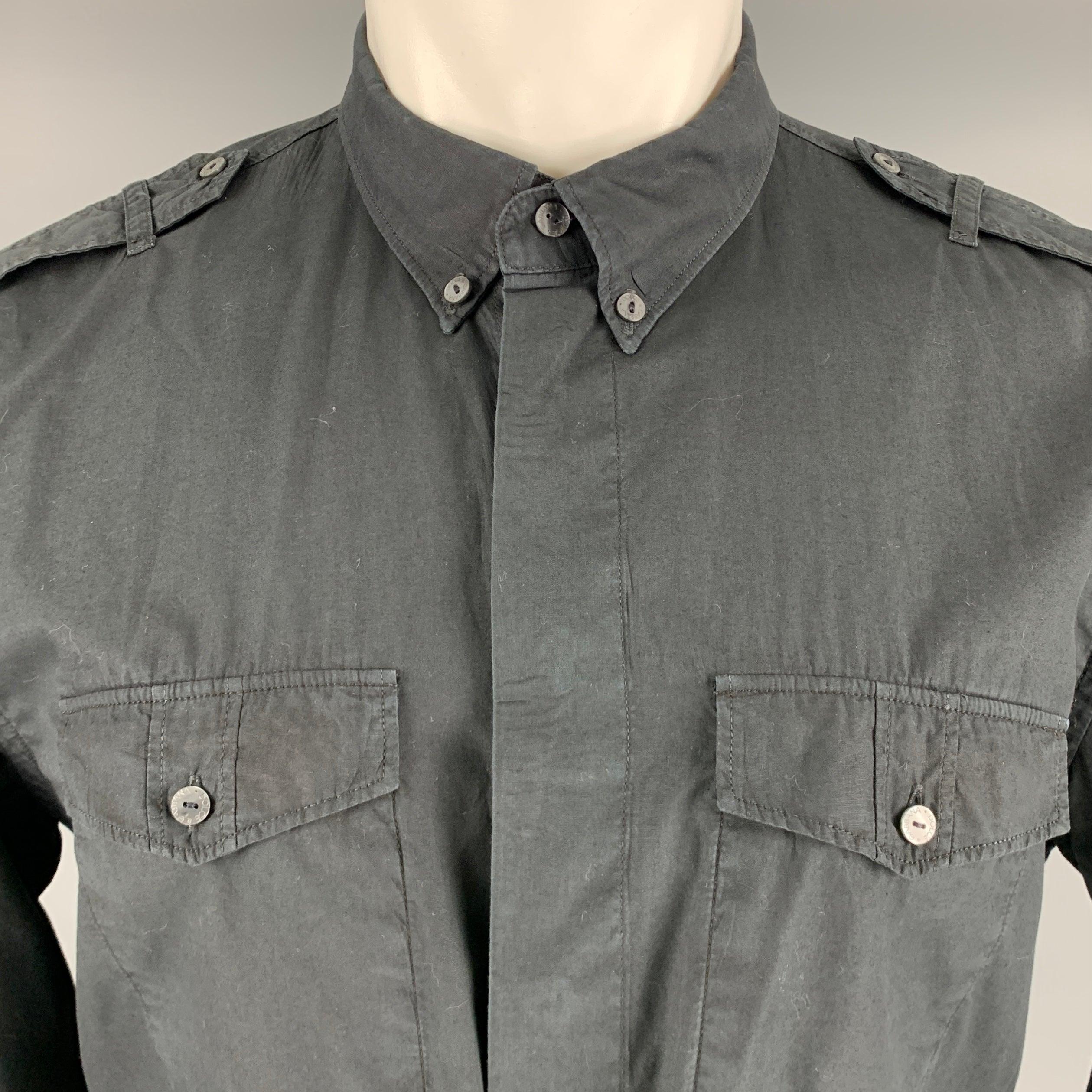 DOLCE & GABBANA long sleeve shirt
in a black cotton woven fabric featuring epaulettes, two button pockets, a button down collar, and button closure. Made in Italy.Very Good Pre-Owned Condition. Some light fading. One of the tabs for roll tab sleeves