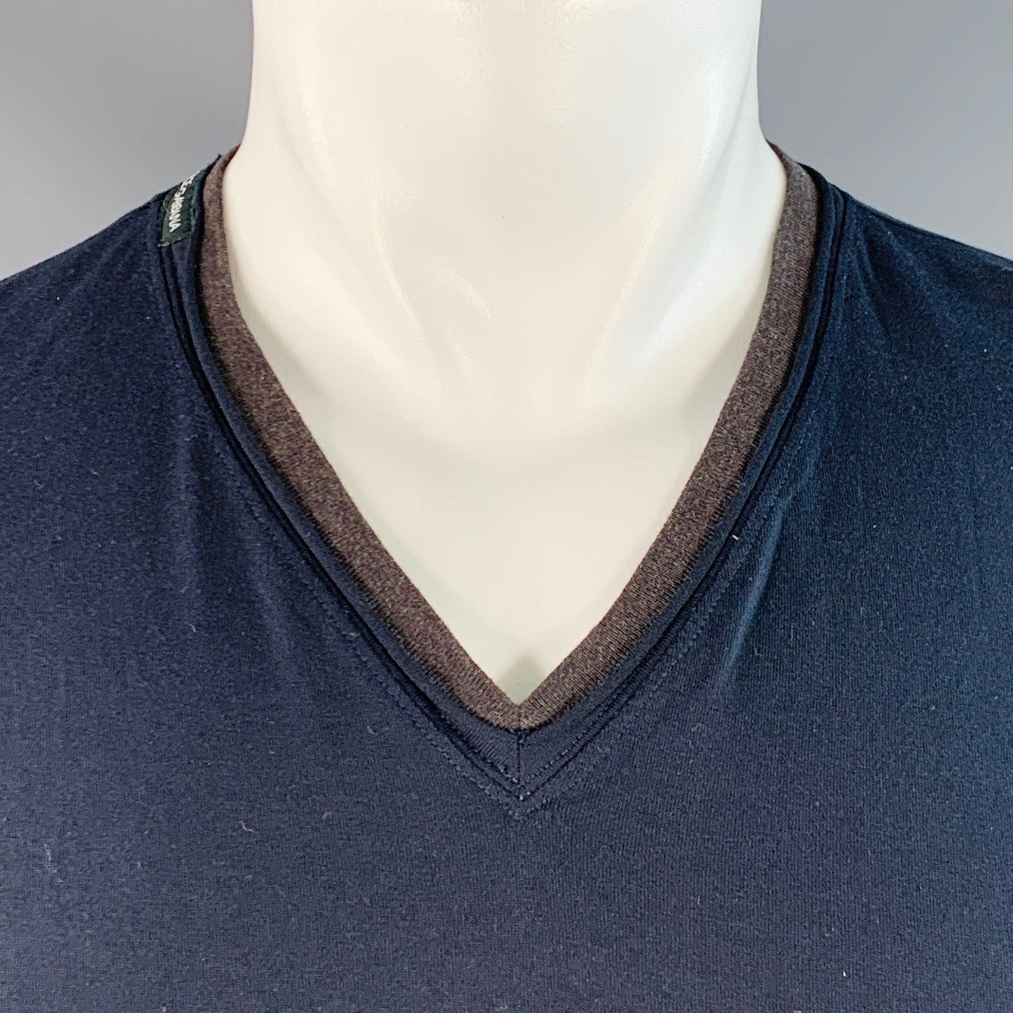 Maglietta Dolce & Gabbana
in jersey di cotone grigio e blu, caratterizzato da un finto stile a strati con bordi arrotolati, maniche corte e scollatura a V. Made in Italy. Eccellente condizione di usato. 

Contrassegnato:   IT 48 

Misure: 
 
Spalla: