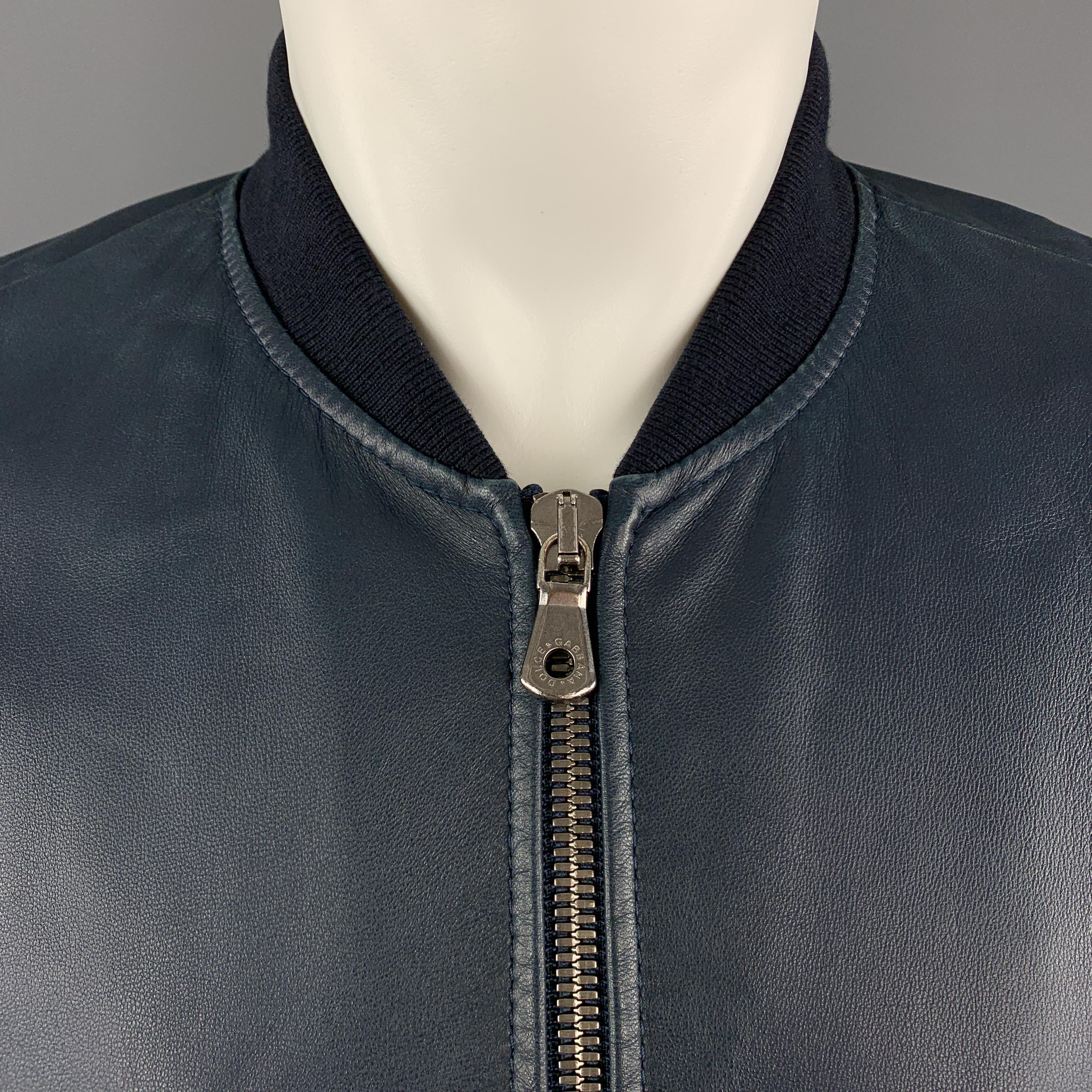 DOLCE & GABBANA slim fit bomber jacket comes in navy leather with a baseball collar, double zip front, and zip pockets. Made in Italy.

New with Tags.
Marked: IT 46

Measurements:

Shoulder: 16 in.
Chest: 38 in.
Sleeve: 26 in.
Length: 25 in.