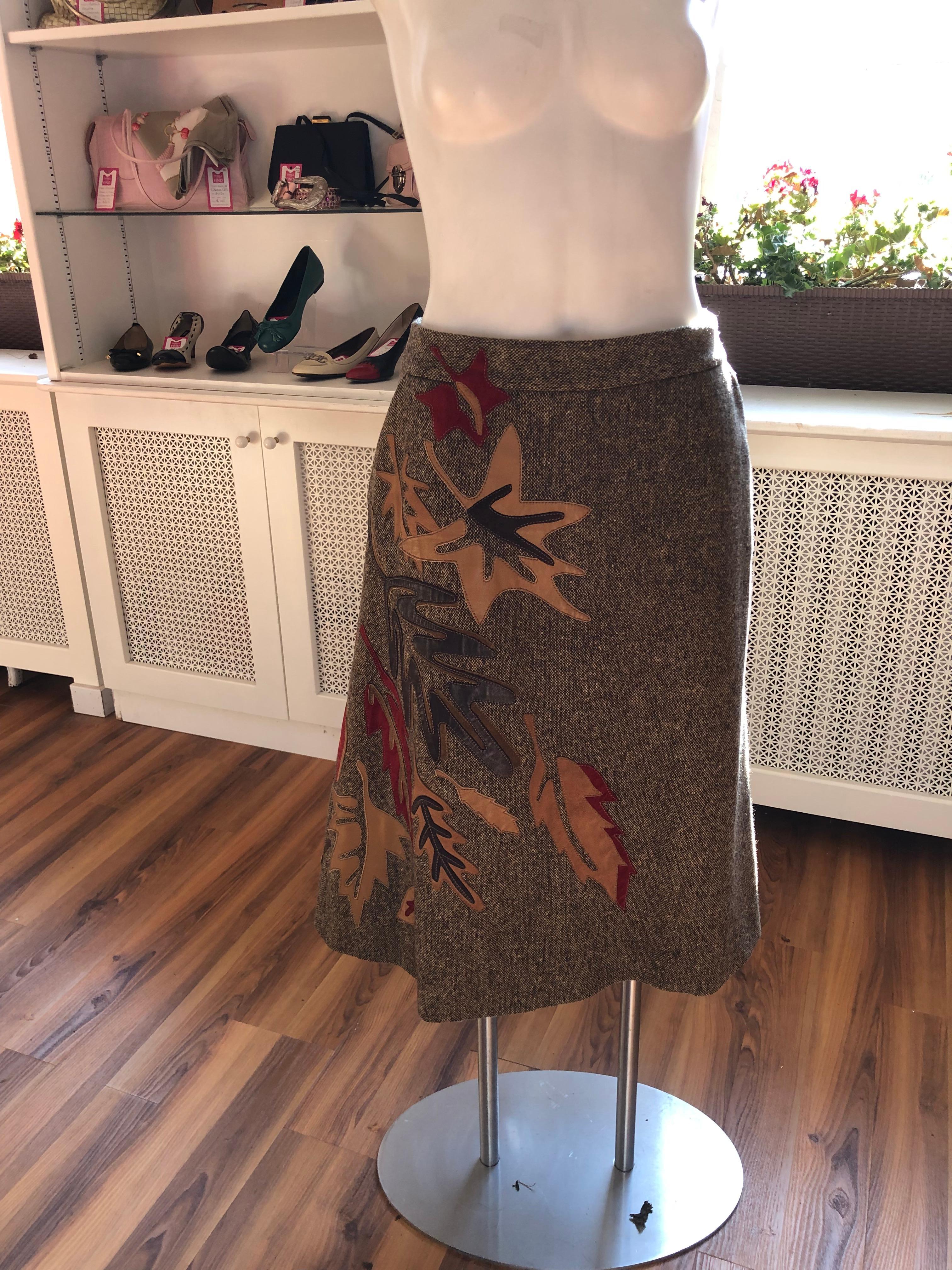 Superb brown brick tweed skirt with autumn colored suede and leather leaf appliques. The applique is strategically positioned on half the front and back and the colors are burnt red/orange, brown and beige. There are two slash pockets and the skirt