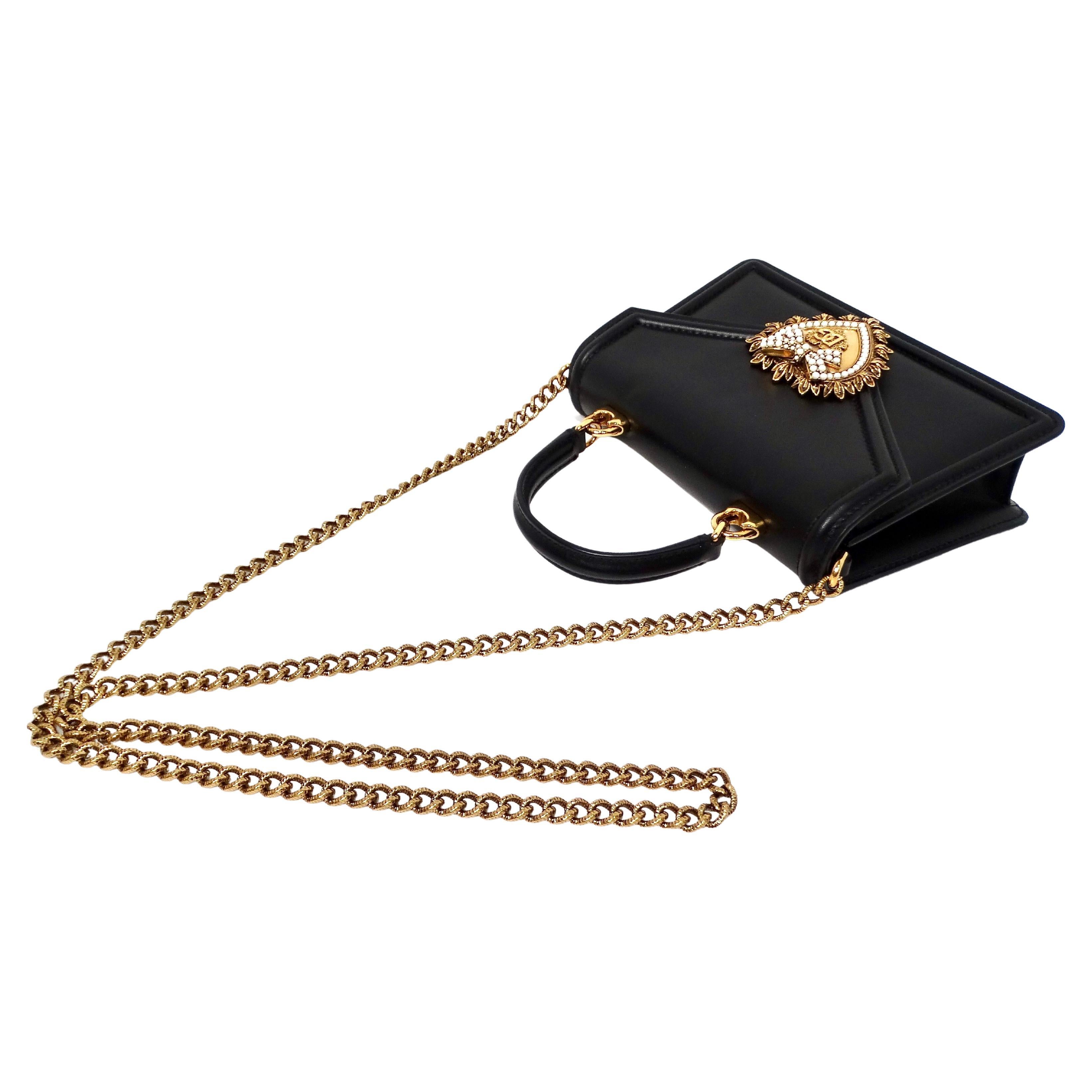 The Dolce & Gabbana Small Black Calfskin Devotion Top Handle Bag is a luxurious and versatile accessory that epitomizes sophistication and timeless elegance. Crafted from high-quality black calfskin leather, this bag features a sleek, minimalist