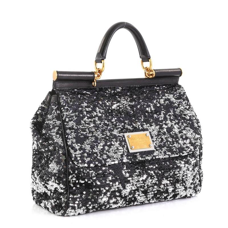 This Dolce & Gabbana Soft Miss Sicily Bag Sequins Large, crafted in black and silver sequins, features a leather top handle, matte aged gold-tone hardware. Its framed top flap with magnetic snap closure opens to a black satin interior with zip and