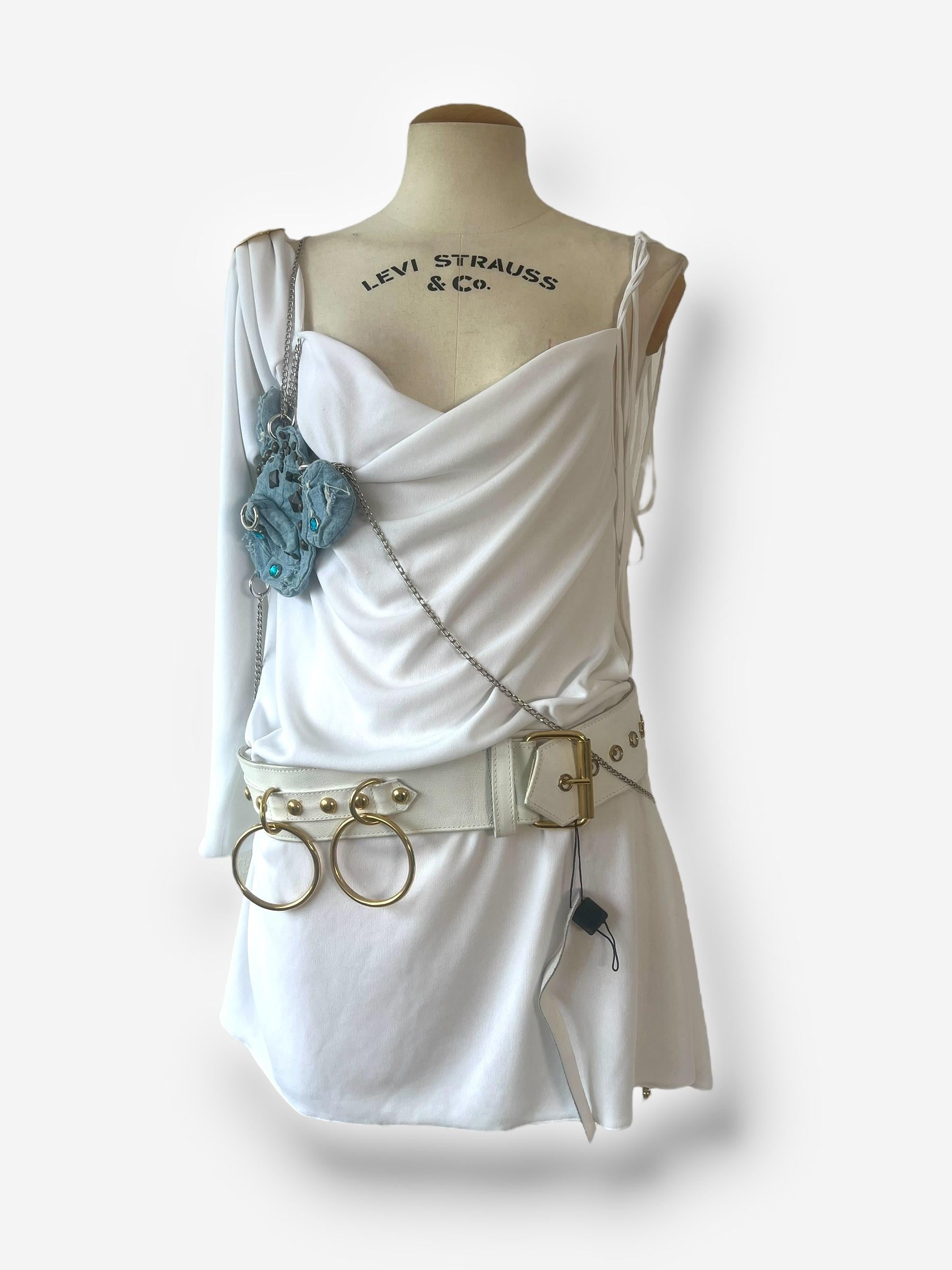 This iconic D&G dress from the Spring/Summer 2003 collection is a true masterpiece, inspired by Roman styles and featuring a striking contrast of white fabric with a denim inset. The dress is exquisitely handcrafted with hand-applied studs,