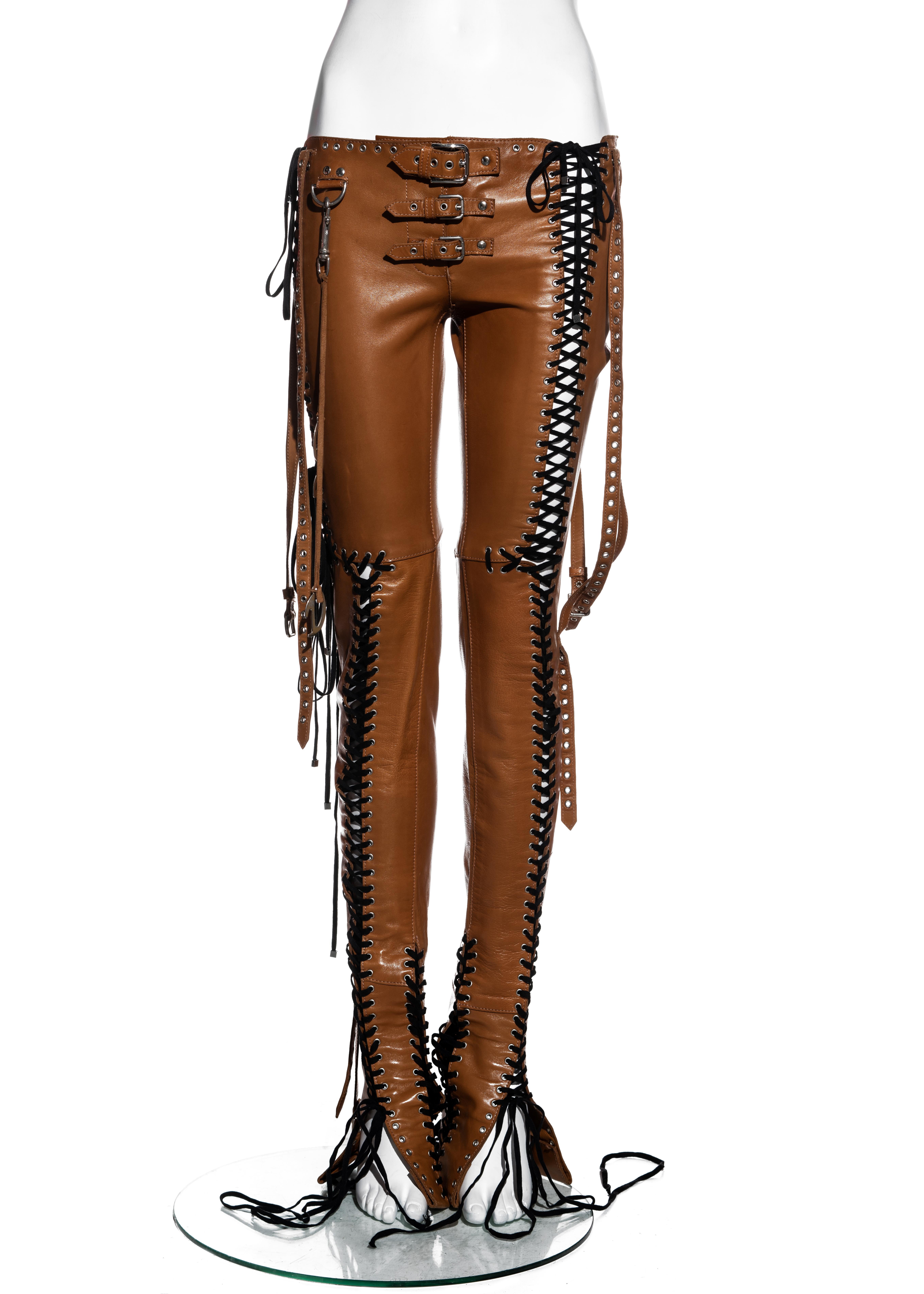▪ Dolce & Gabbana tan leather pants 
▪ 100% Sheepskin leather 
▪ Metal grommets 
▪ Multiple black lace-up fastenings 
▪ Three buckles at waist 
▪ Four long belt straps hanging from hips 
▪ Hanging metal 'D' and 'G' detail 
▪ Size IT 38 - FR 34 - UK
