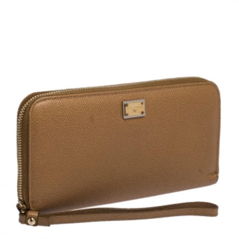 Conçu pour vous aider, ce portefeuille beige Dolce & Gabbana est fabriqué en cuir et doté d'une fermeture à glissière à trois voies et de la plaque du logo sur le devant. Il est doté de plusieurs fentes et d'une pochette zippée pour l'argent liquide