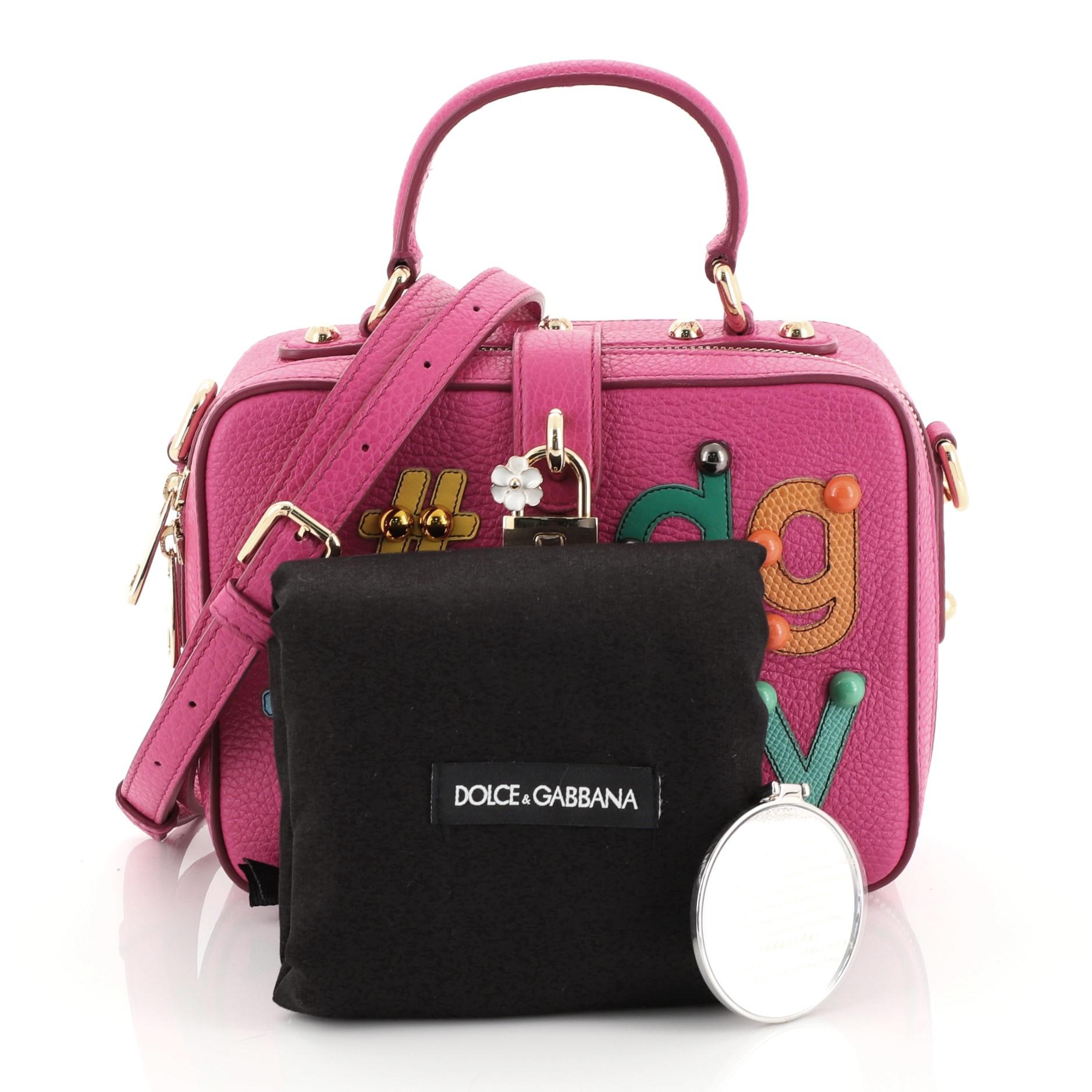 This Dolce & Gabbana Treasure Box Bag Embellished Leather Small, crafted in embellished pink leather, features a leather top handle, #DG family patch, and gold-tone hardware. Its padlock style turn-lock closure opens to a black print fabric interior