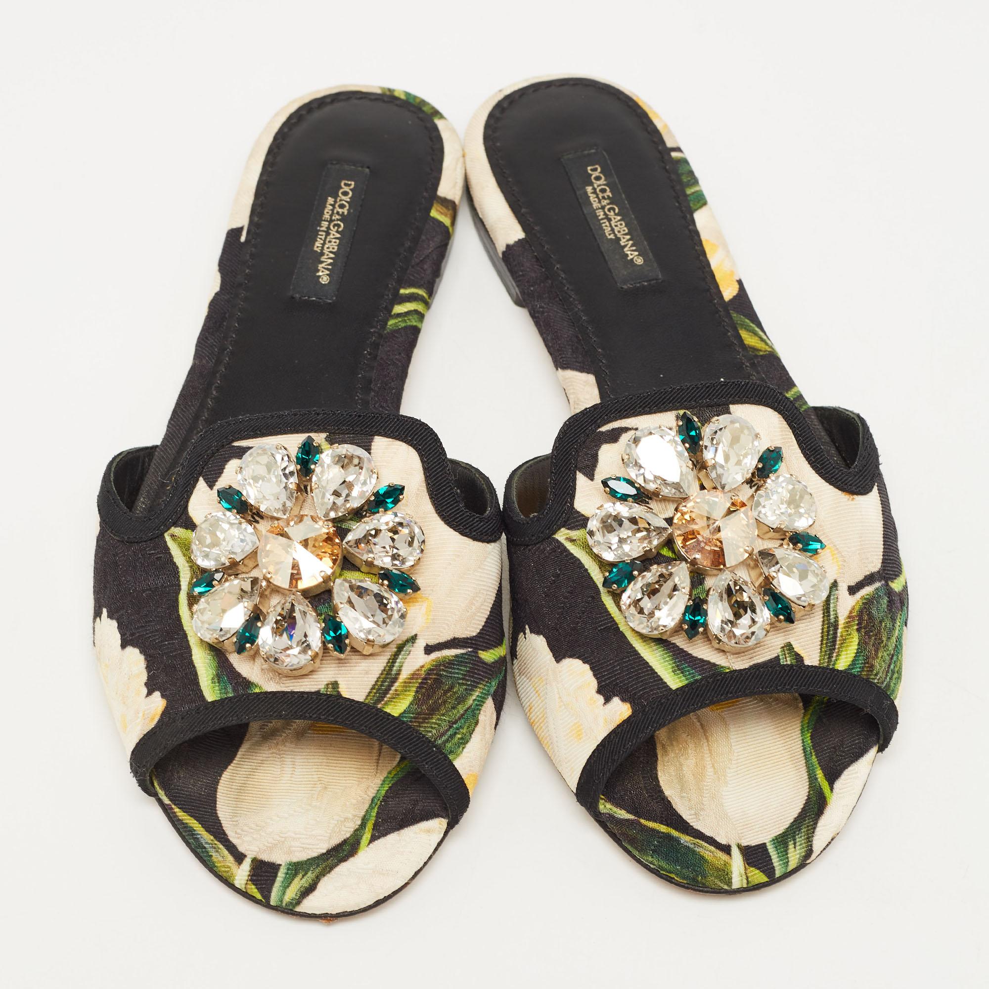 Present your feet with utmost comfort by choosing these flat slides from the house of Dolce & Gabbana. They are crafted from eye-catching printed canvas and detailed with a crystal-embellished bow on the uppers. They are complete with durable