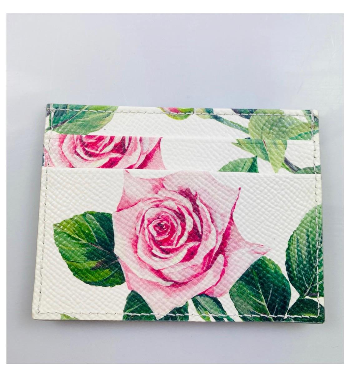  Dolce & Gabbana Tropical Rose
printed cardholder

Grained calfskin card holder in white
featuring graphic floral pattern printed
in multicolor throughout. Logo
hardware at face. Four card slots and
one note slot. Black textile lining. Gold-

tone