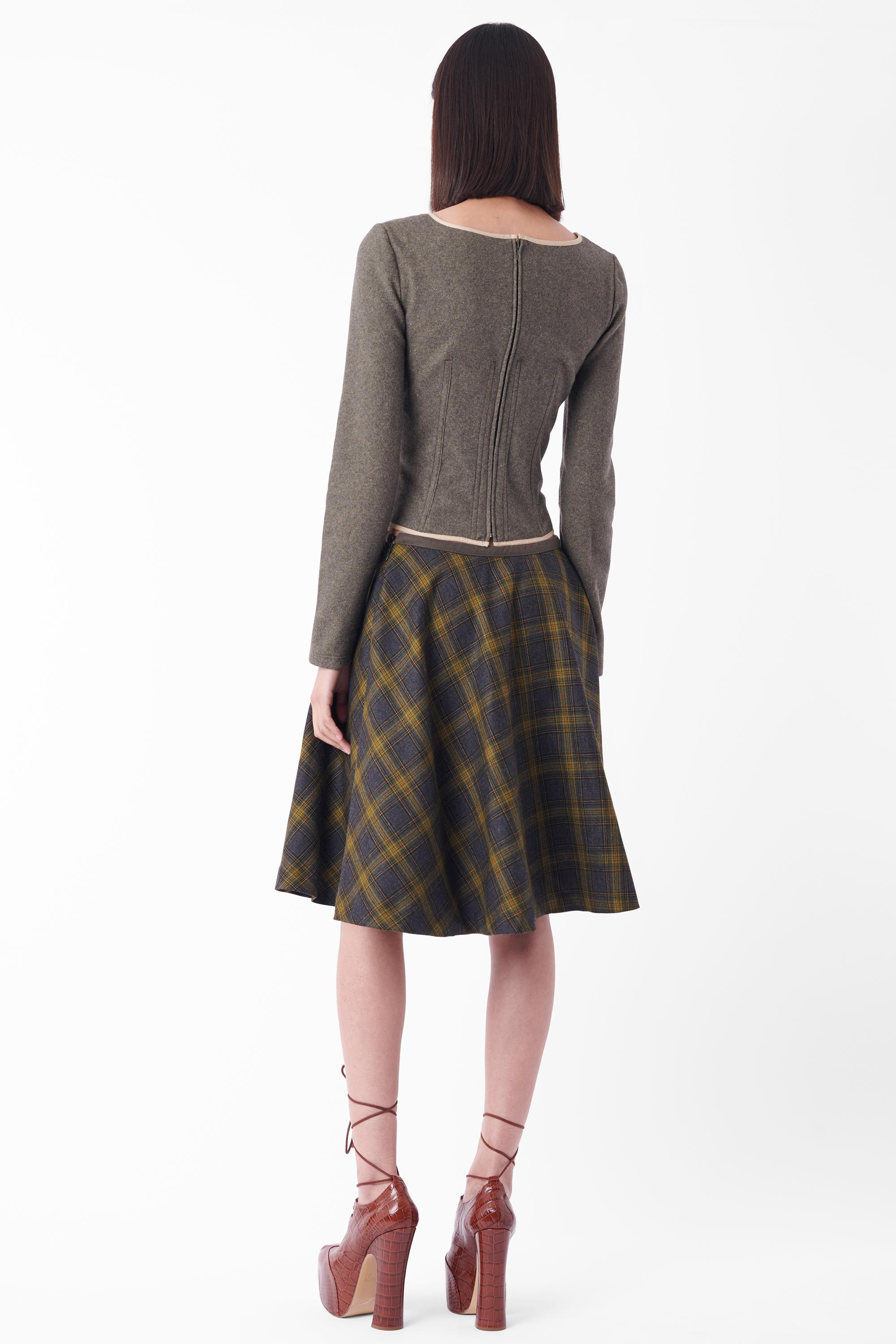 We are excited to present this Vintage D&G long sleeve corset and tartan skirt set. Corset features brushed grey fabric, corset cups, lace front detailing with silver hardware and boning with zip back. Skirt features a grey waistband,  green plaid