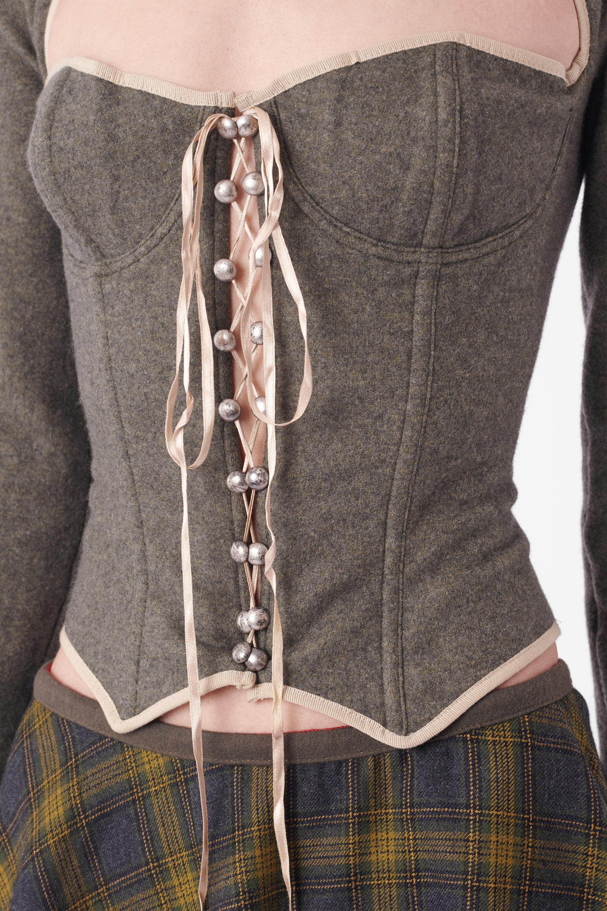 Vintage D&G long sleeve corset and tartan skirt set. Corset features brushed grey fabric, corset cups, lace front detailing with silver hardware and boning with zip back. Skirt features a grey waistband,  green plaid print and invisible zip. In
