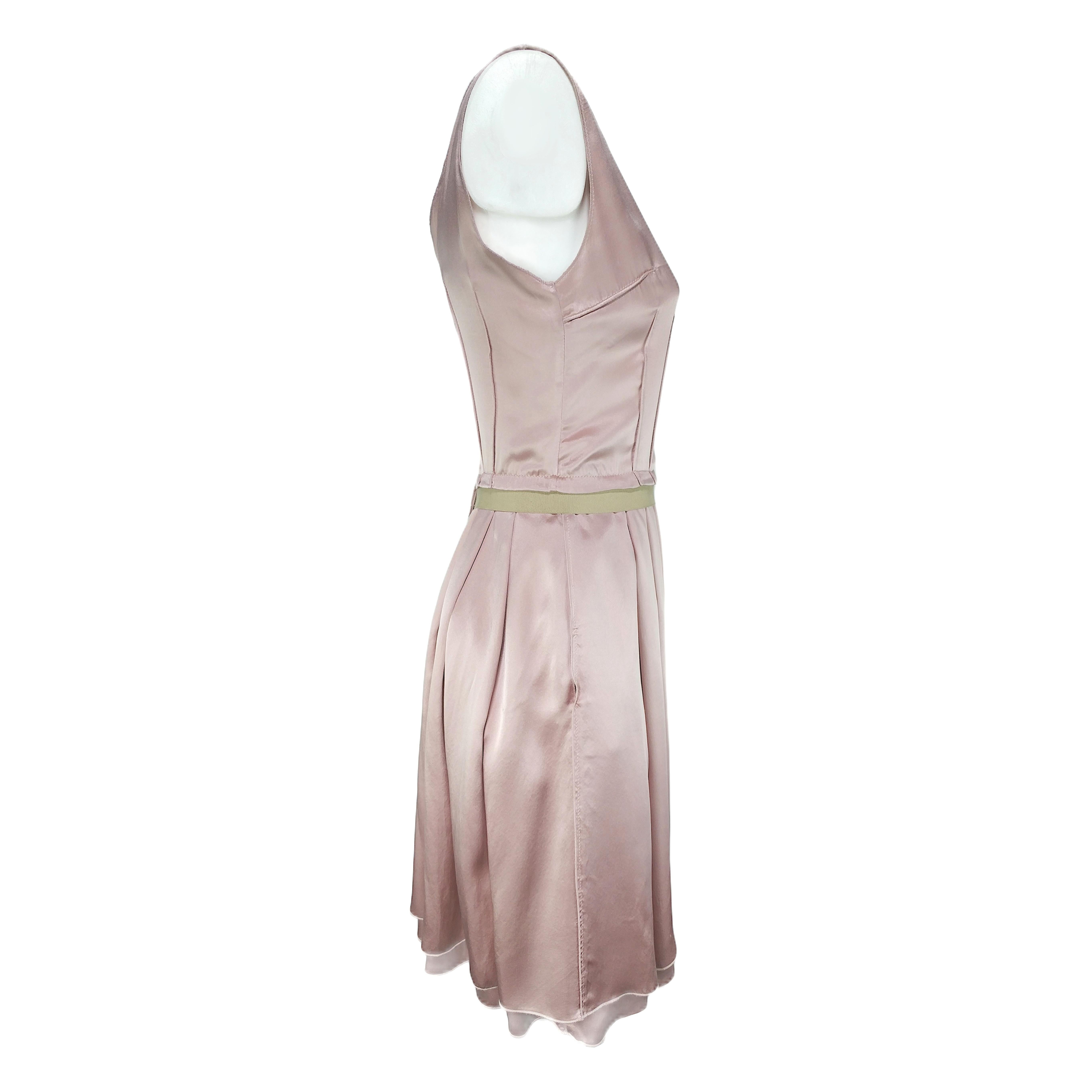It is a pre-owned Dolce & Gabbana midi dress in pastel rose-pink, featuring a pleated half-circle skirt, a scoop neckline, two side pockets and a zip on the back side with hook-and-eye closure. The zip puller carries the Dolce&Gabbana logo and the