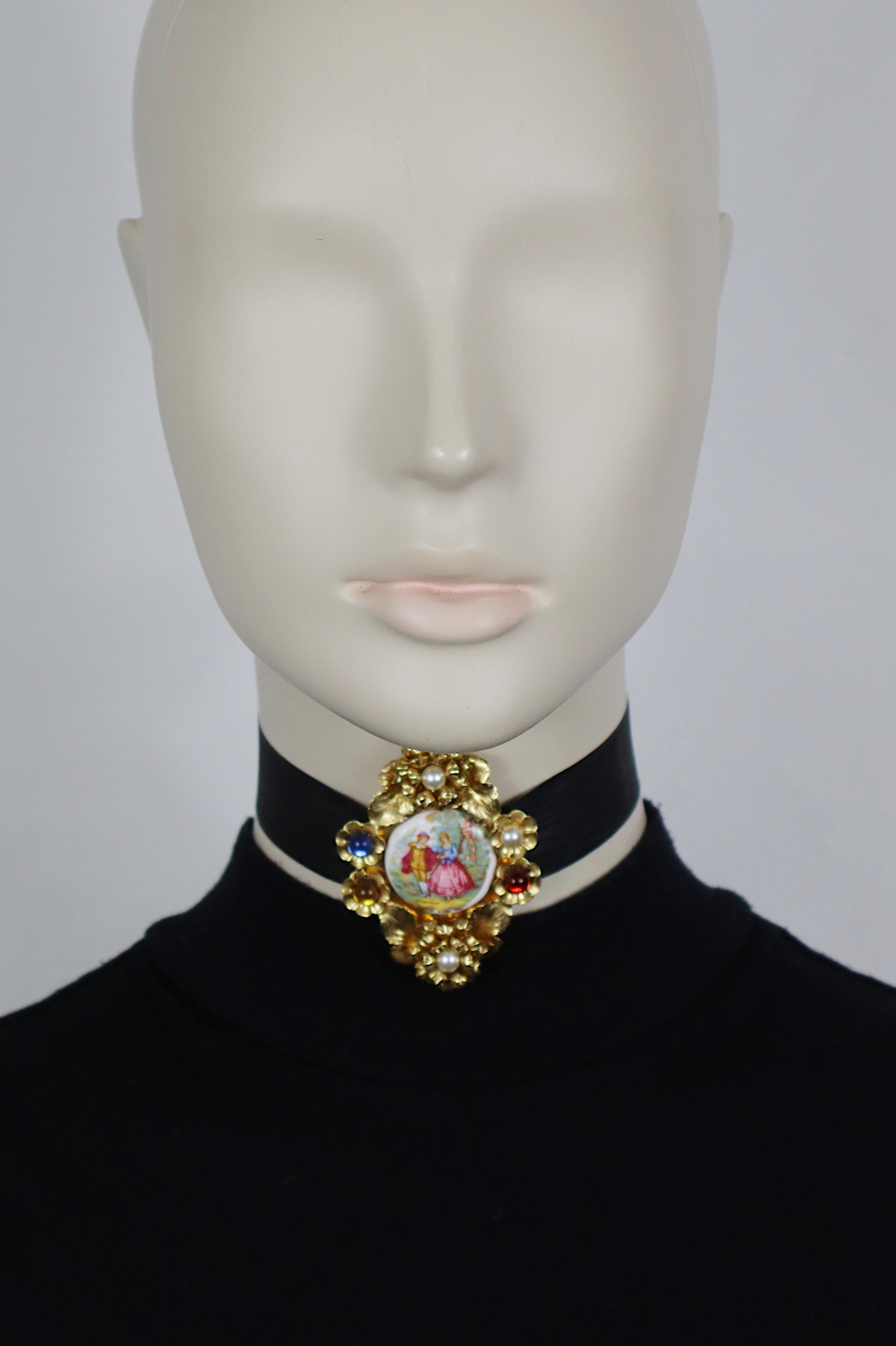 DOLCE & GABBANA vintage 1992 choker necklace featuring a 17th century scene of gallantry print on oval porcelain in a gold tone metal setting embellished with multicoloured glass cabochons and faux pearls.

Ties around the neck with a black satin