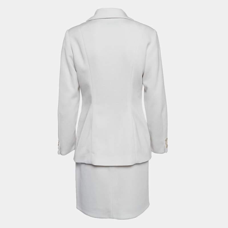 Lean into sophisticated tailoring with this Dolce and Gabbana vintage skirt suit. The design in white fabric pairs a single breasted blazer with a matching skirt.
