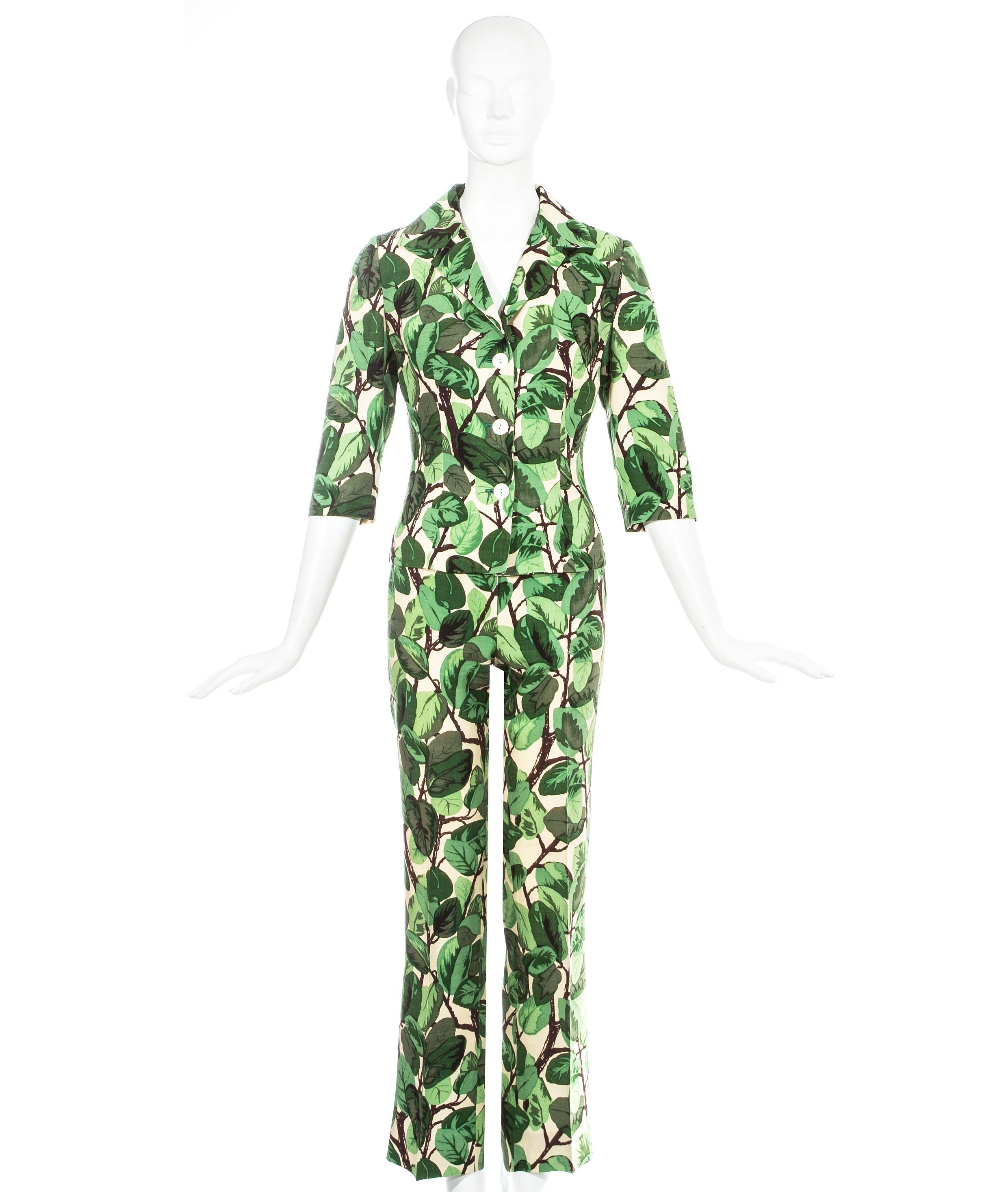 Dolce & Gabbana Hosenanzug aus Seidenleinen mit weißem und grünem Blattwerk. Taillierte Jacke mit angeschnittenen Ärmeln und schmal geschnittene Hose.

Frühjahr-Sommer 1997
