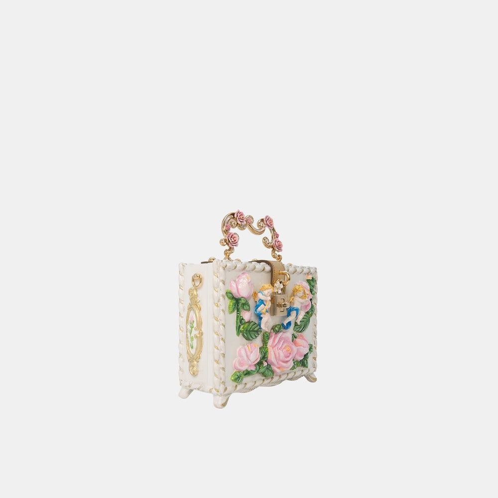 Experience the Dolce Vita with this Dolce & Gabbana box bag, adorned with eye-catching 3-D floral appliqué. Inspired by Renaissance style, it features all-over rose and angel embellishments. The bag includes a front lock closure, a rose-decorated