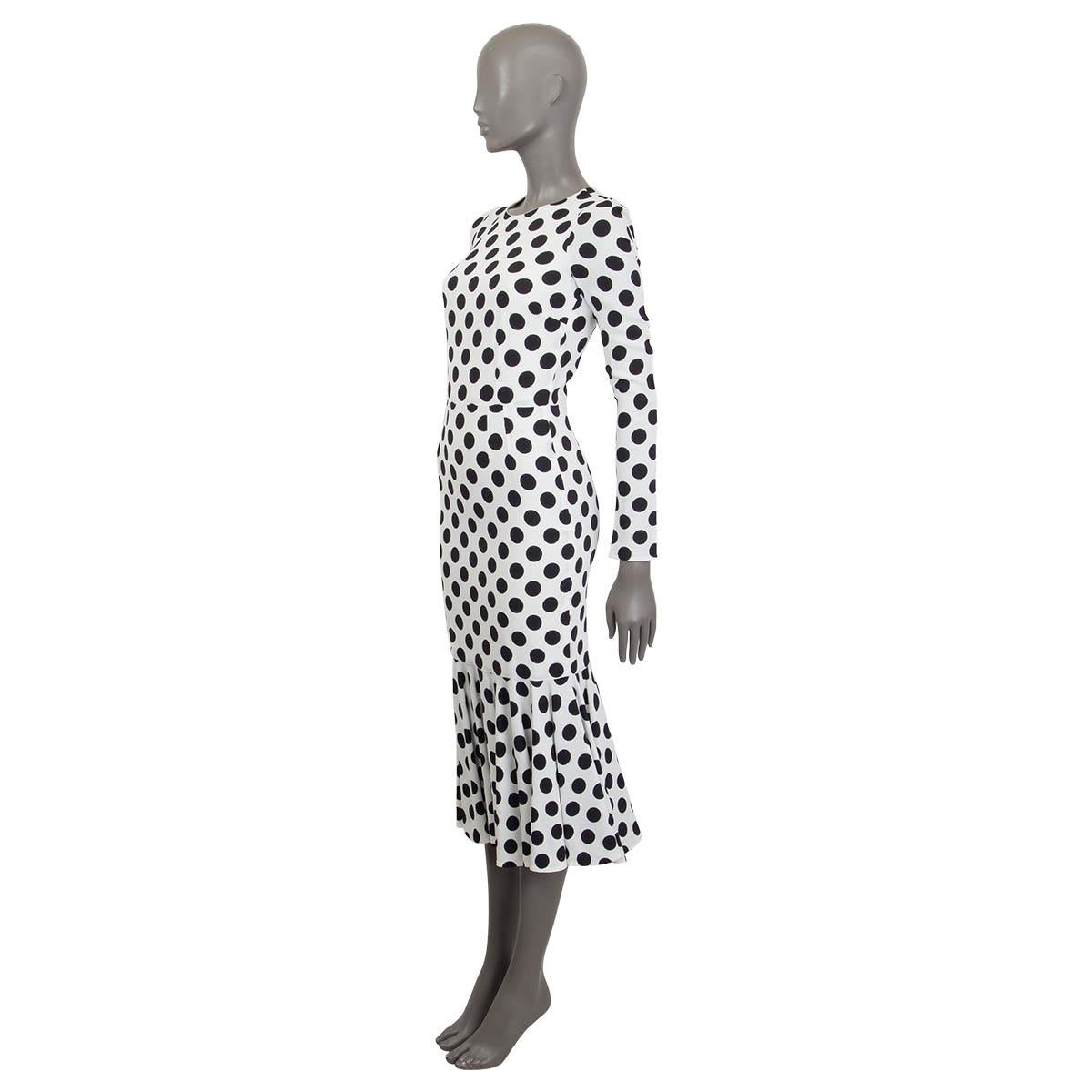 100% authentic Dolce & Gabbana polka dot maxi dress in white and black viscose (100% - please note the content tag is missing). Features a ruffled hemline and long sleeves. Opens with a concealed zipper and a hook at the back. Lined in off-white
