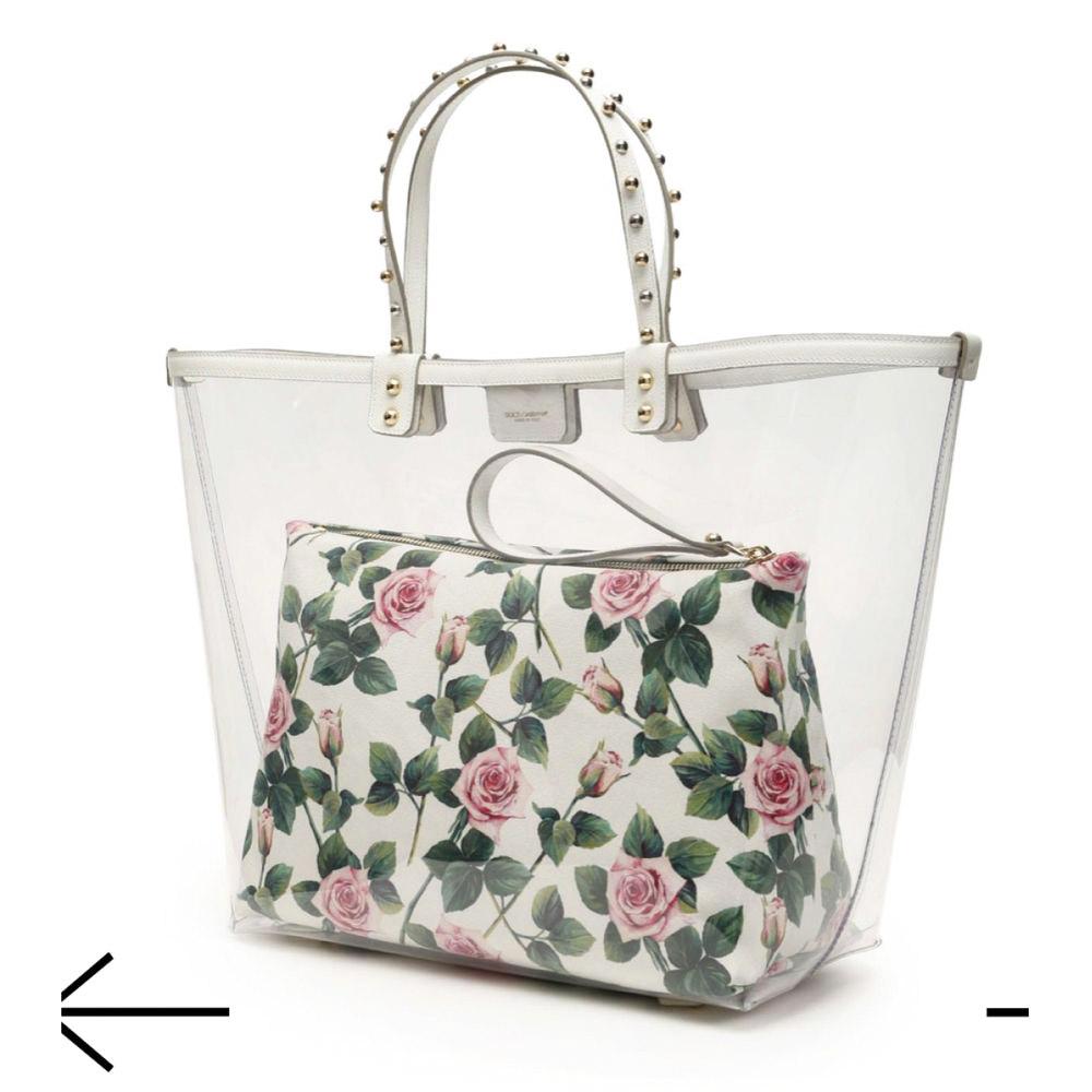 Shopping bag Dolce & Gabbana Beatrice in pvc trasparente con finiture in pelle, manici in pelle borchiata, chiusura con bottone magnetico, piedini in metallo sul fondo, monogramma DG applicato in metallo sul davanti. Dotata di una custodia