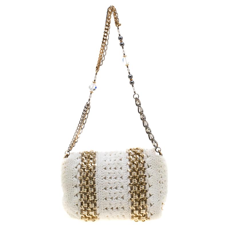 This bag will give one a feeling of being chic and in fashion. Featuring a stylish design, this bag comes in a crochet fabric body with gold-tone metal chain detailing. This unique bag by Dolce & Gabbana, equipped with a fabric interior and a chain