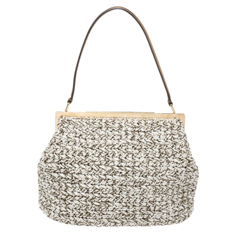 An essential wardrobe accessory, this Dolce and Gabbana bag is surely a must-have. Crafted in Italy, it is made of quality leather and rafia. It comes in stunning hues of white and dark gold. It exudes glamour and style and is equipped with a single