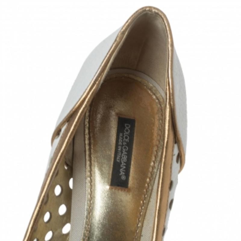 How beautiful are these pumps from the House of Dolce & Gabbana! They are designed using white-gold perforated leather and flaunt a bow detail on the peep-toes. They have a slip-on style, gold-tone hardware, and pointy heels. Match these pumps with