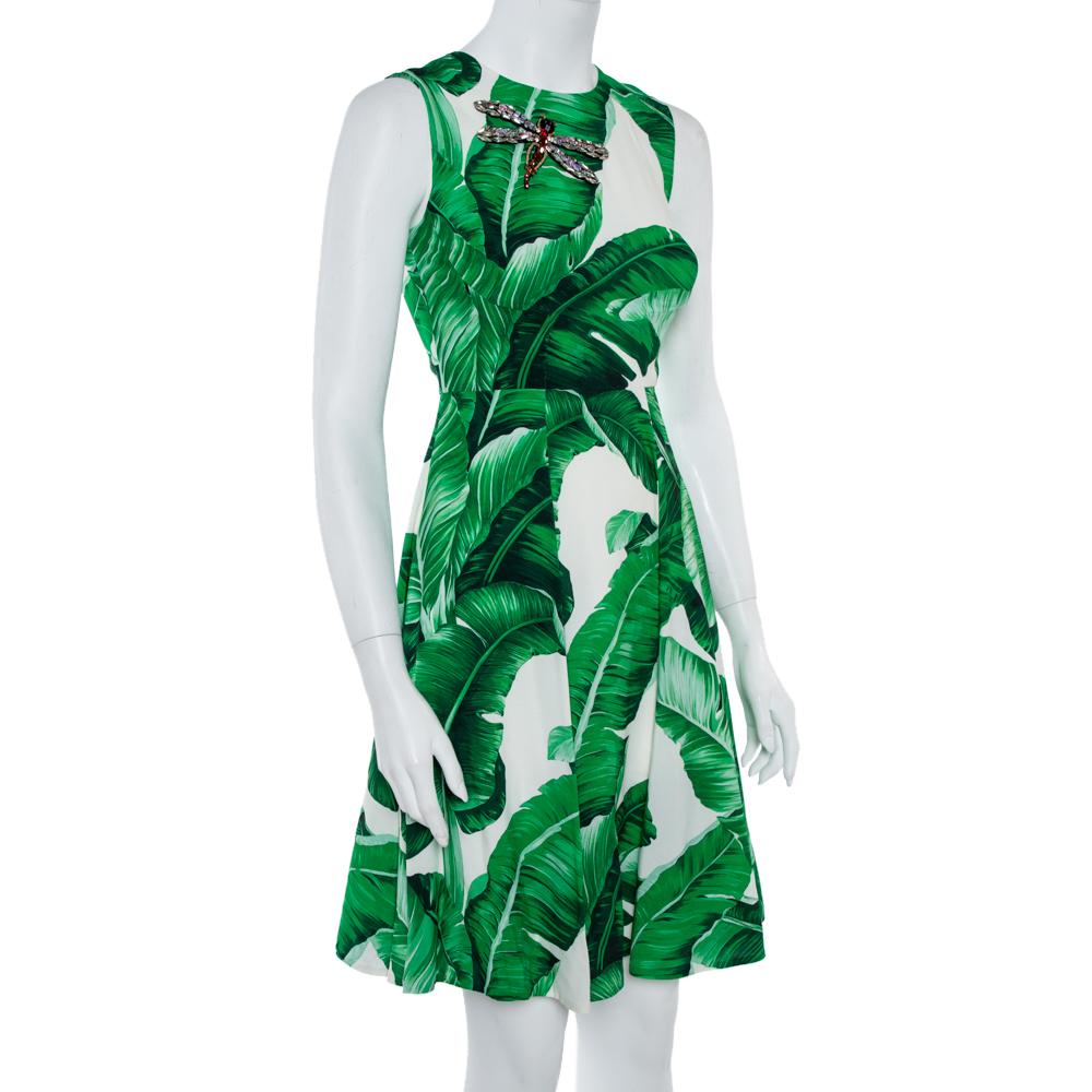 Dolce & Gabbana loves to interpret tropical prints! This eye-catching dress is cut to a signature silhouette with a round neck and pleated skirt. It's printed with vibrant green banana leaves and features a scattering of sequins and