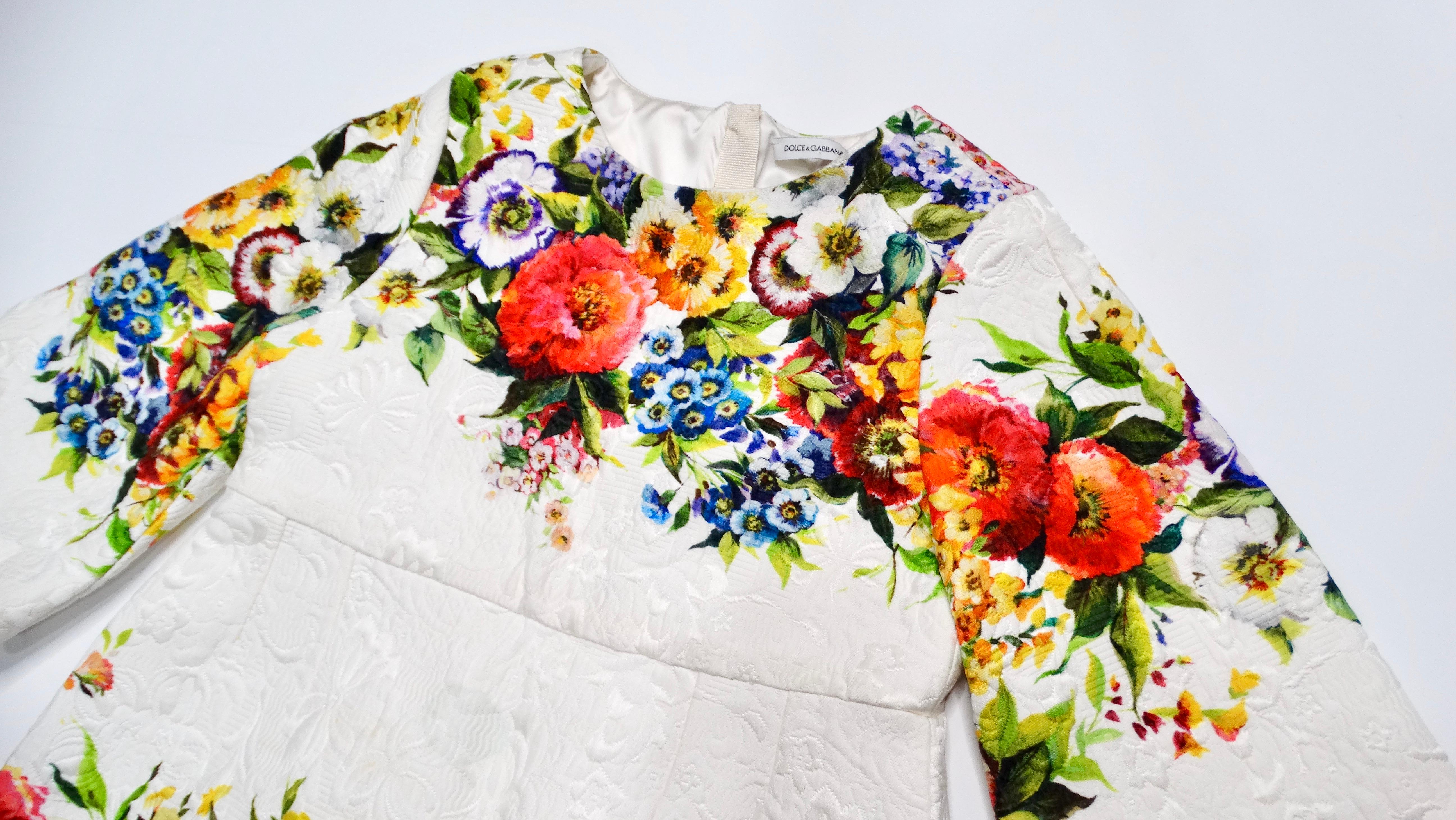 Let your little girl step out in style with the charming Dolce & Gabbana White Jacquard Floral Print Children’s Dress. Perfect for special occasions or sunny days, this delightful dress features a white backdrop adorned with vibrant multicolored