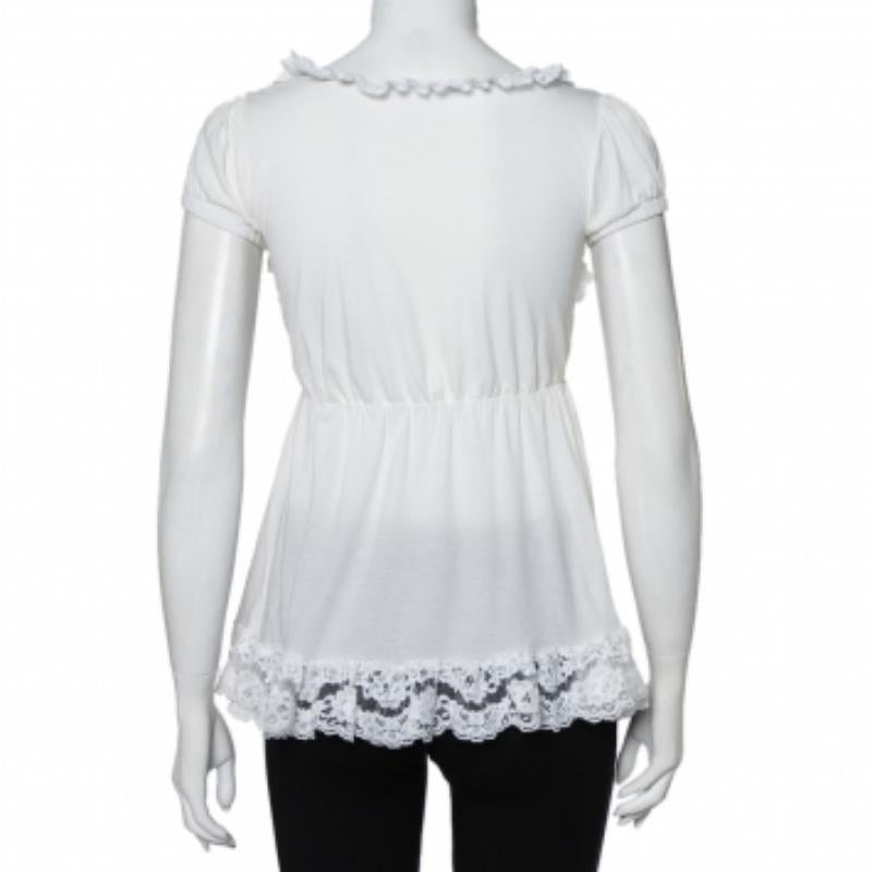 This designer top by Dolce & Gabbana skillfully merges fine craftsmanship and elegant details with a casual silhouette. The women's top has short sleeves, ruffle trims, and a lace trim on the hem. The creation is accompanied by a waist tie detail.