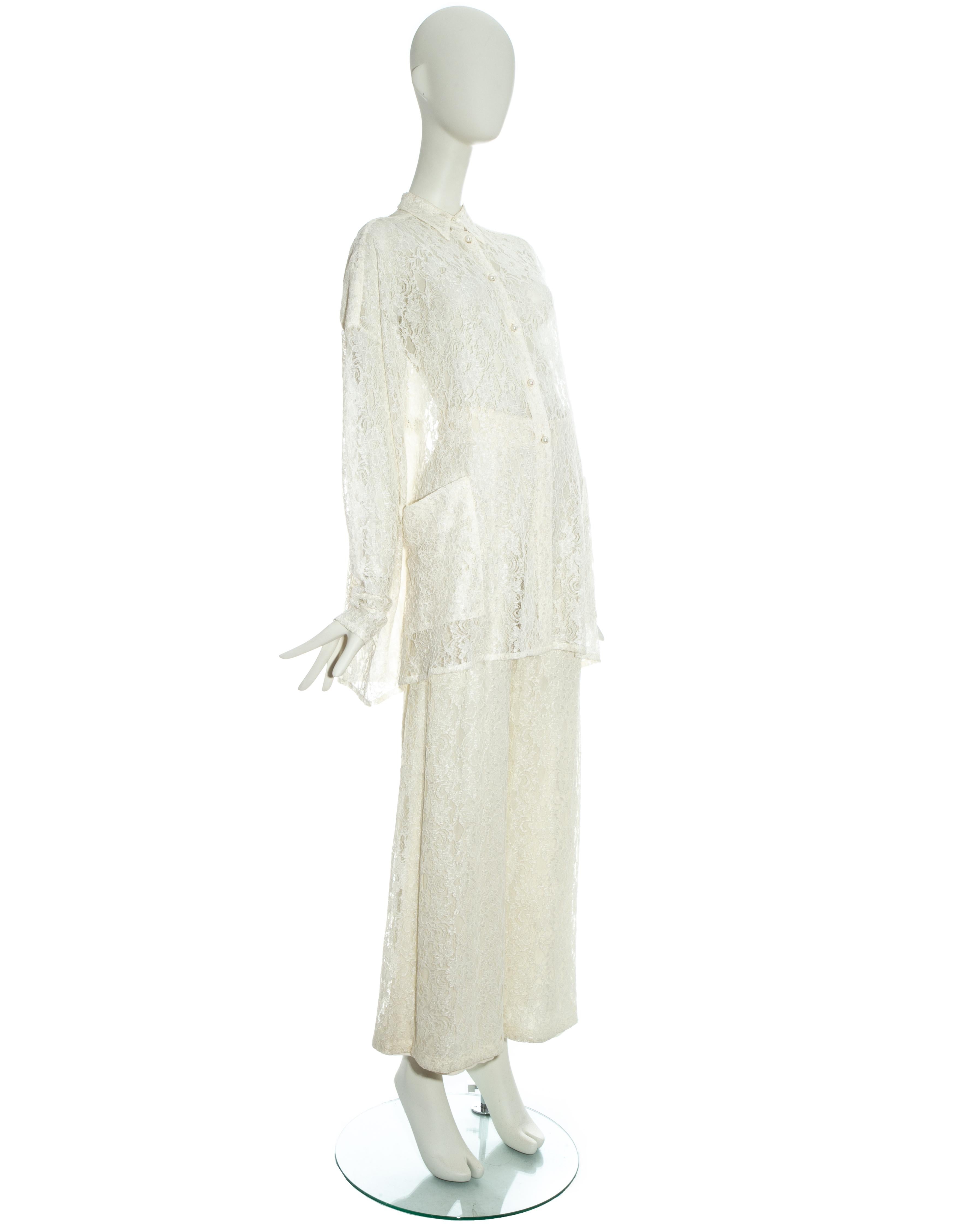 Dolce & Gabbana white lace flared pant suit. Loose cut blouse with front pockets and pearl buttons. High waisted flared pants with lining.

Spring-Summer 1993