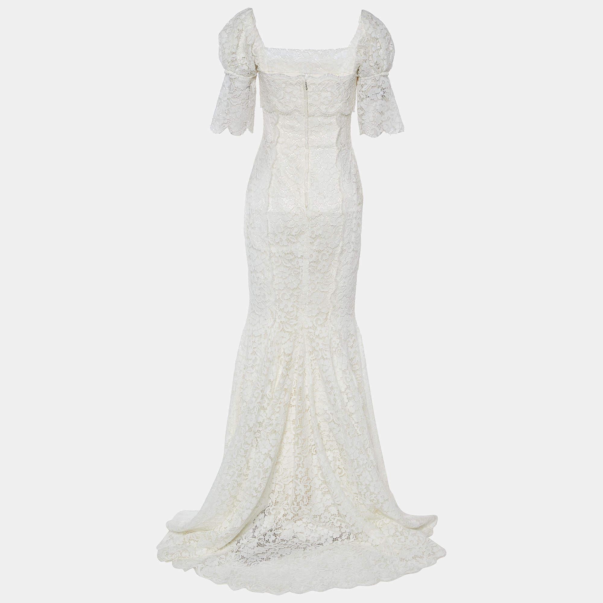 The Dolce & Gabbana wedding gown is an exquisite masterpiece of bridal fashion. Crafted from luxurious white lace, this gown features intricate ruching that accentuates the bride's curves, while a trail adds a touch of elegance. With its romantic