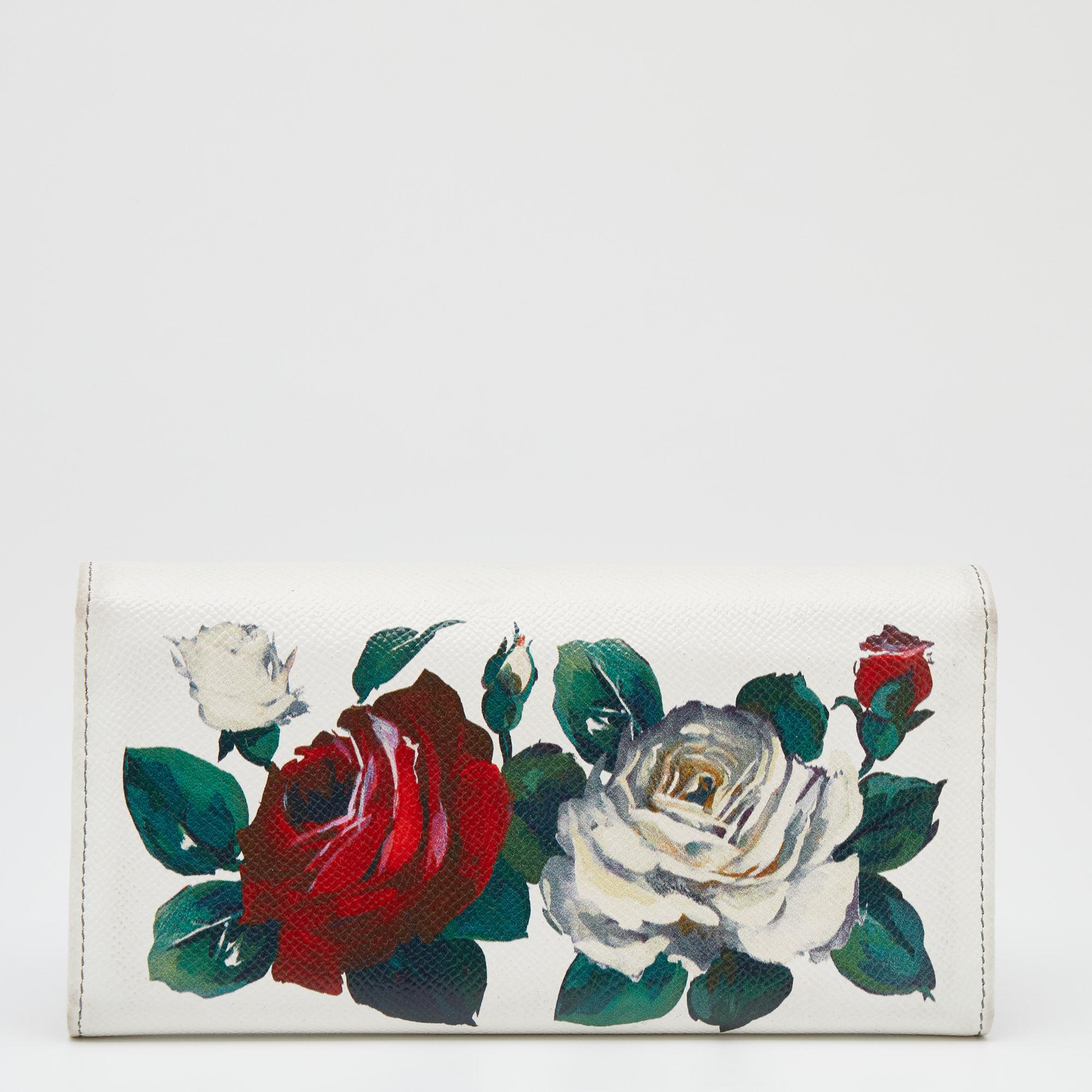 Carry this Dolce & Gabbana continental wallet in style! It is crafted from leather and has a white hue with a lovely floral print. The pretty wallet is complete with a front flap that opens to several compartments that can easily hold your cards.