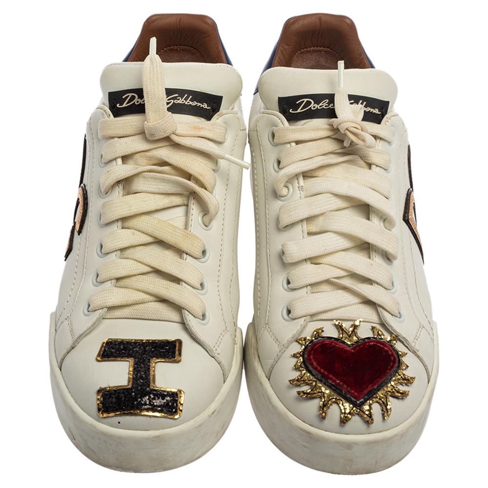 You're sure to feel your best in these Portofino Sacred Heart low-top sneakers by Dolce & Gabbana. Crafted using quality leather, the trendy white shoes carry round toes, lace-ups on the vamps, and detailing of I love( heart motif) DG. Finished with